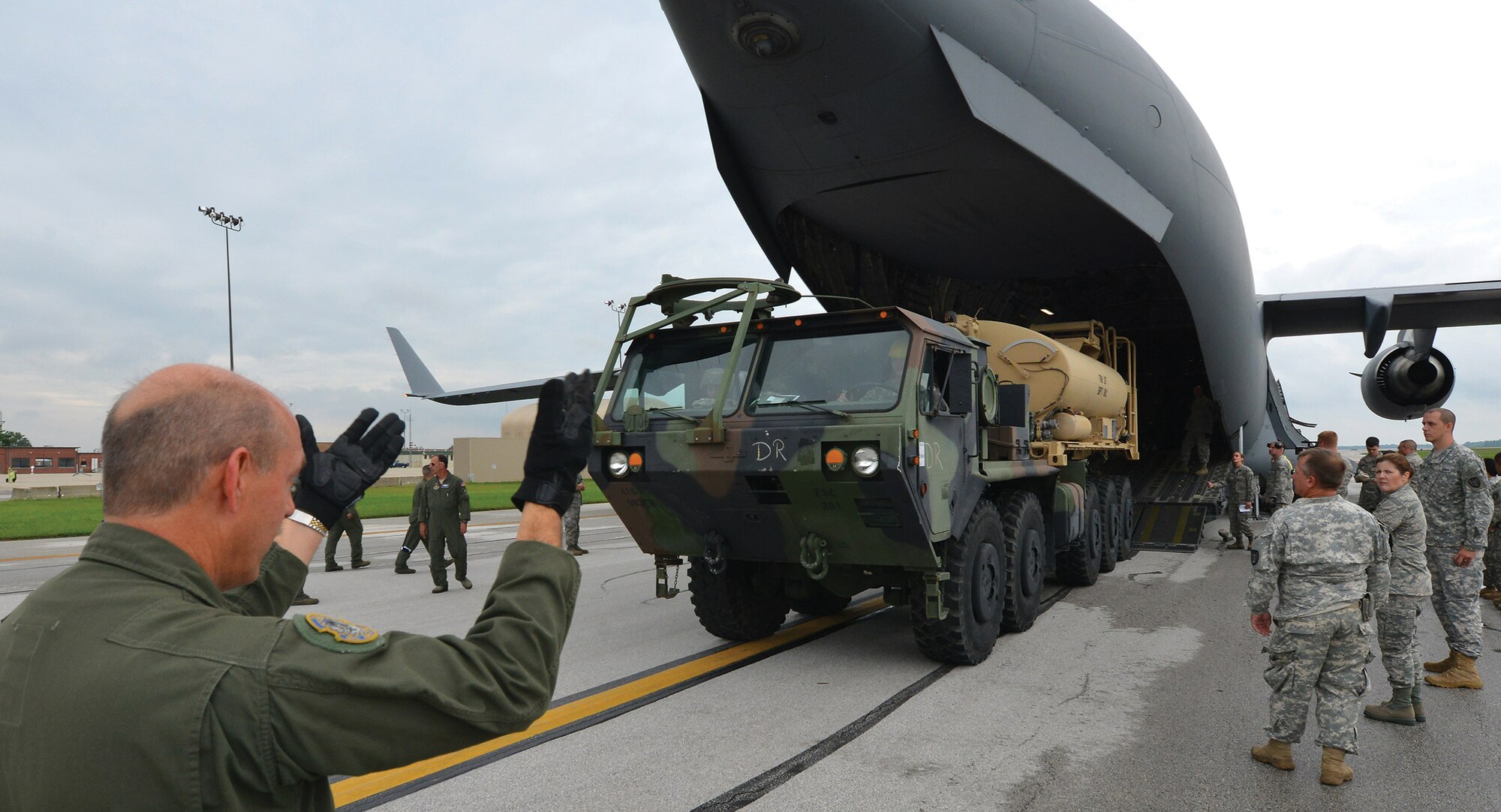 TOLEDO, Ohio - Senior Master Sgt. Gary Fernandez guides a five-ton Army vehicle off a 445th Airlift Wing C-17 Globemaster III Sept. 6, 2014 at the Toledo Express Airport. Sixteen loadmasters from the 89th Airlift Squadron were training Army Reserve and Air National Guard members on the art of loading the transport aircraft. The unique loads included two five tons trucks, a mobile command center. (U.S. Air Force photo/Tech. Sgt. Frank Oliver)