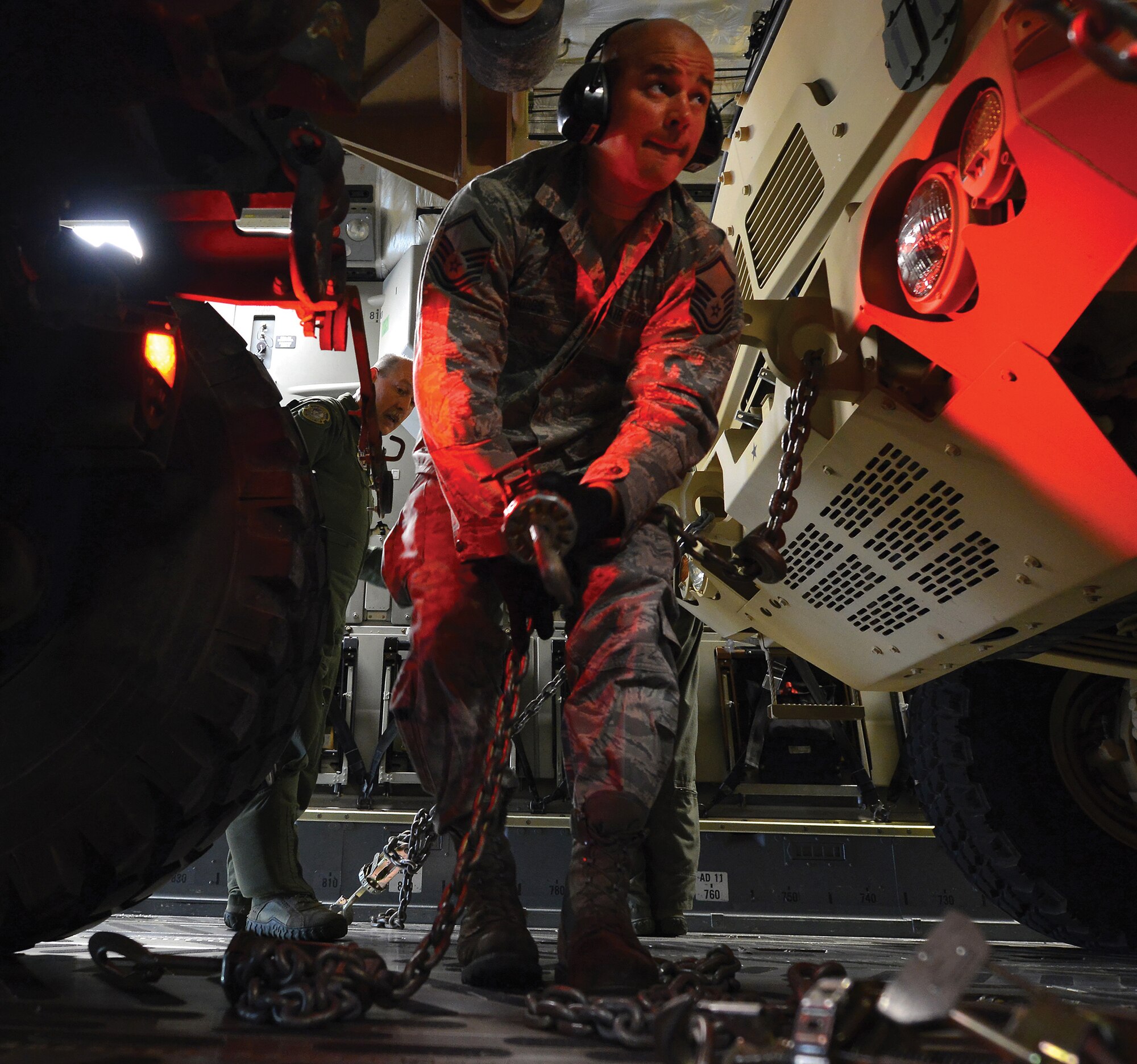TOLEDO, Ohio - Under the watchful eyes of Senior Master Sgt. Gary Fernandez, left, a member of the Ohio Air National Guard learns how to properly chain and secure a vehicle on a 445th Airlift Wing C-17 Globemaster III at the Toledo Express Airport Sept. 6, 2014. Sixteen loadmasters from the 89th Airlift Squadron were training Army Reserve and Air National Guard members on the art of loading the transport aircraft. The unique loads included two five tons trucks, a mobile command center. (U.S. Air Force photo/Tech. Sgt. Frank Oliver)