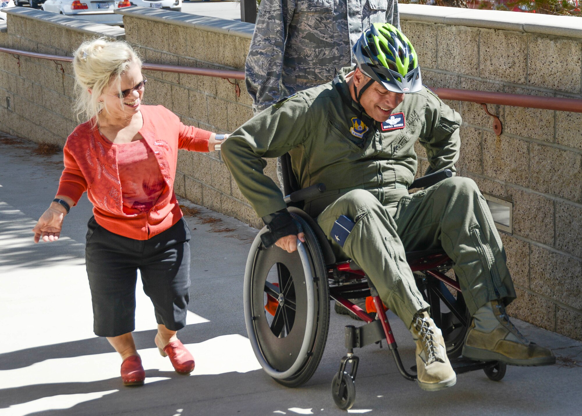 With the guidance of Darcy Painter, 412th Communications Squadron, Brig. Gen. Michael T. Brewer, 412th Test Wing commander, rolls up the ramp to Bldg. 3000 to attend the weekly Test Wing Staff Meeting Sept. 31. Brewer took on the wheelchair challenge to officially kick off National Disability Employment Awareness Month here at Edwards. The challenge is to give leaders a better perspective of people with disabilities. A helmet was provided as Brewer is not accustomed to using a wheelchair. (U.S. Air Force photo by Rebecca Amber)