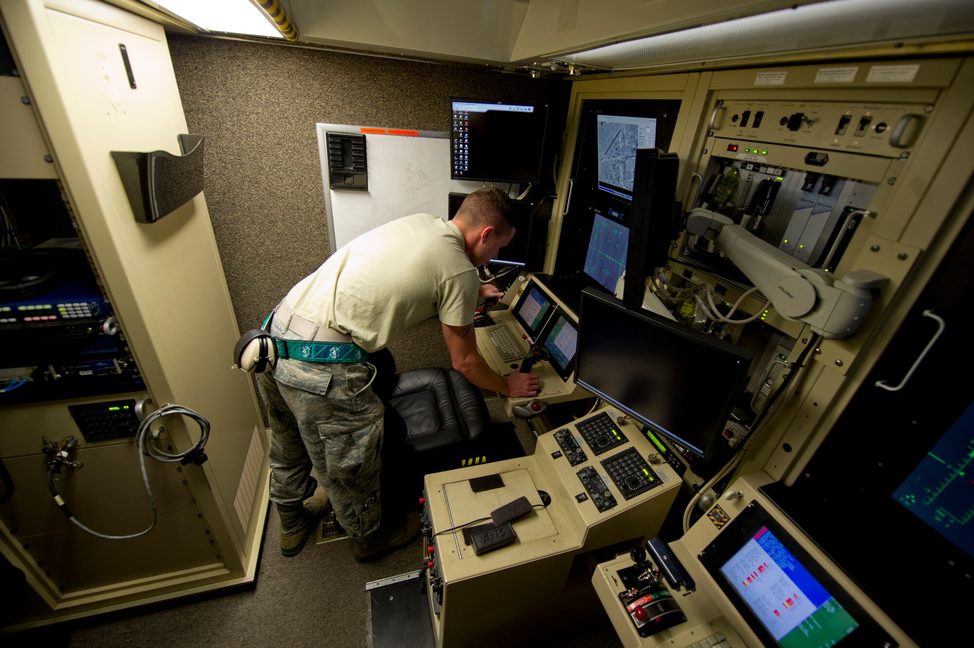 Airman 1st Class Tyler Christian, 49th Communications Squadron ground control station maintainer performs a functionality check on pilot’s control stick inside a ground control station at Holloman Air Force Base, N.M., 25 Sept. The ground control stations are like cockpits for Remotely Piloted Aircraft pilots and their sensor operators. As a ground control station maintainer, Christian is responsible for everything in and around the ground control stations. Holloman AFB is home to the primary training facilities for all RPA pilots and sensor operators in the Air Force, the program is responsible for preparing the flight crews for real-world combat missions down the road. (U.S. Air Force photo by Senior Airman Daniel E.F. Liddicoet/Released)