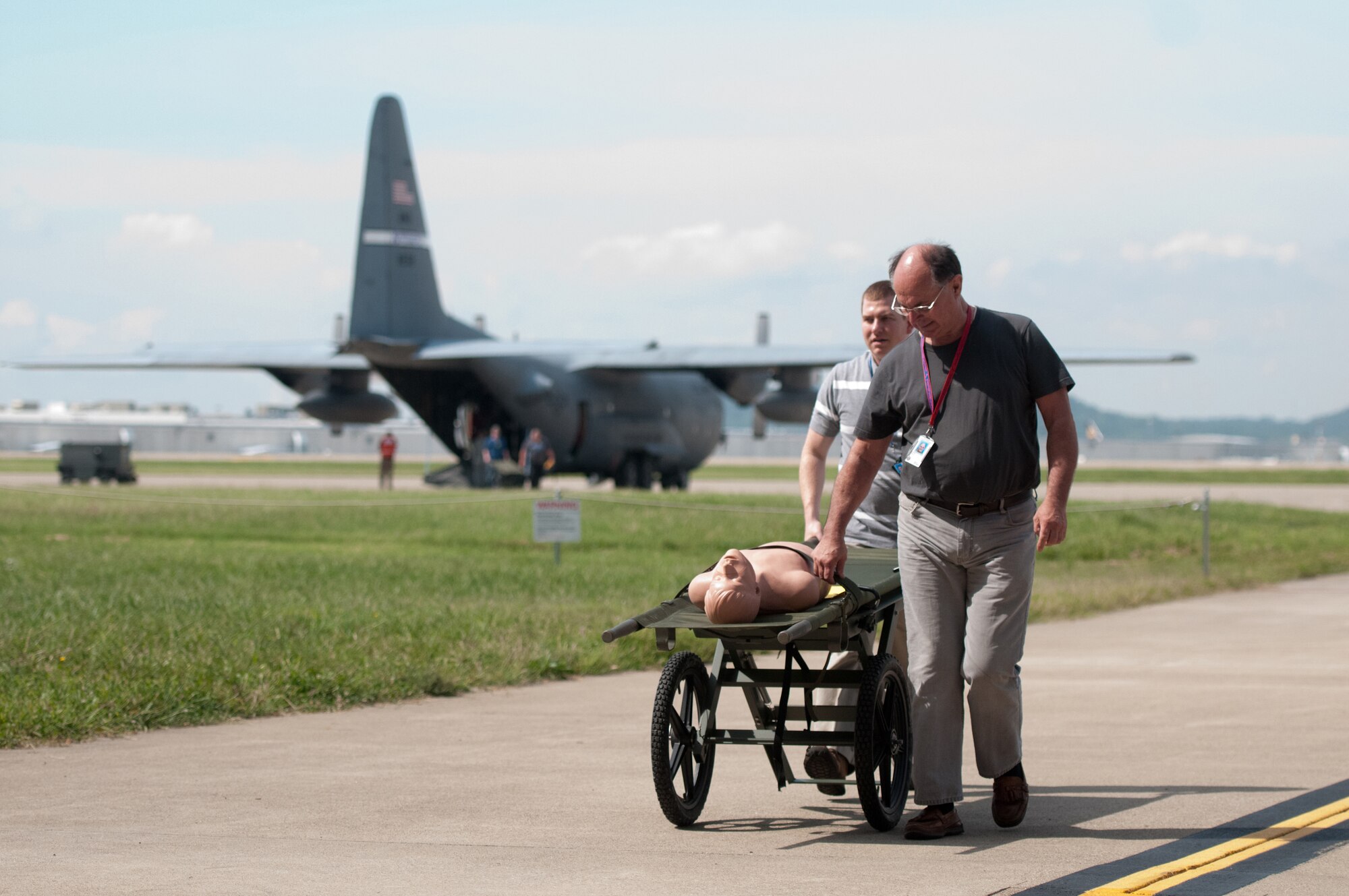 Volunteer litter carriers from the Louisville Veterans Affairs Medical Center roll a simulated patient from a 123rd Airlift Wing C-130 to a hangar at the Kentucky Air National Guard Base in Louisville, Ky., where civilian medical staff were ready to receive patients during a National Disaster Medical System exercise Sept. 9, 2014. The exercise is accomplished every three years. (U.S. Air National Guard photo by Master Sgt. Phil Speck)