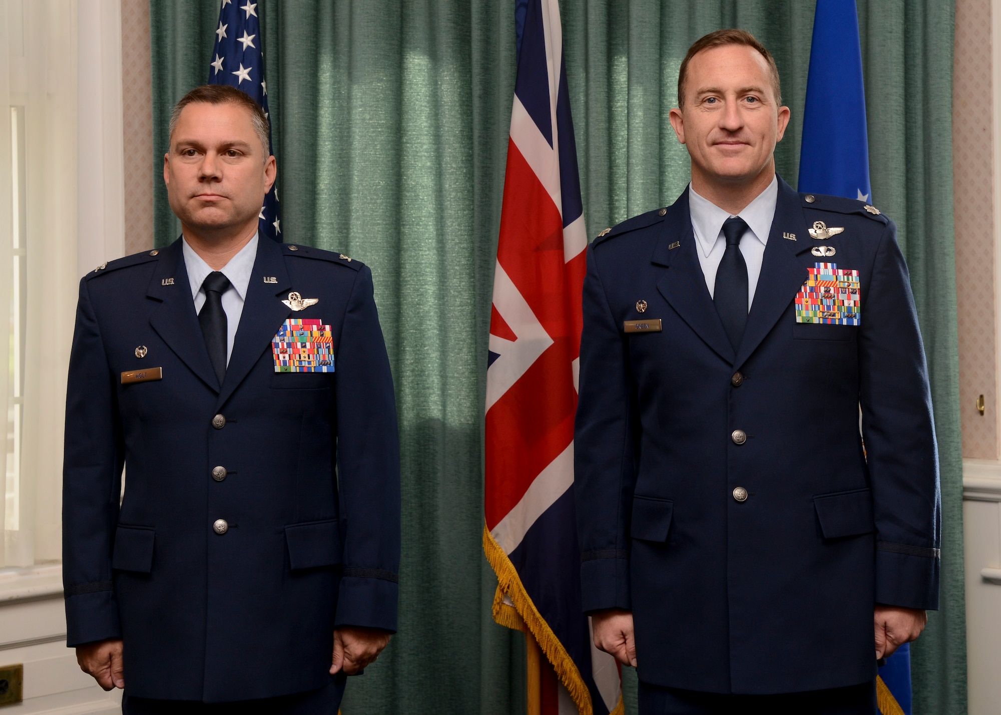 U.S. Air Force Col. William Holt, left, Joint Special Operations Air Component-Europe commander, and then U.S. Air Force Lt. Col. Nathan Green, 352nd Special Operations Group commander, stand at attention during Green’s promotion ceremony Sept. 30, 2014, on RAF Mildenhall, England. Green promoted to colonel and leads the independent 352nd SOG along with five squadrons, 1,100 personnel and 14 aircraft. (U.S. Air Force photo/Senior Airman Victoria H. Taylor/Released)