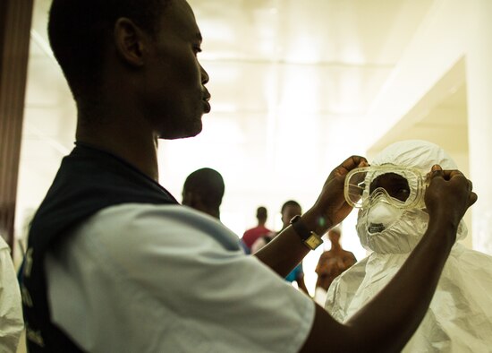 Health care workers put on personal protective equipment before going into the hot zone at Island Clinic in Monrovia, Liberia, on Sept. 22, 2014. (U.S. Agency for International Development photo by Morgana Wingard)
