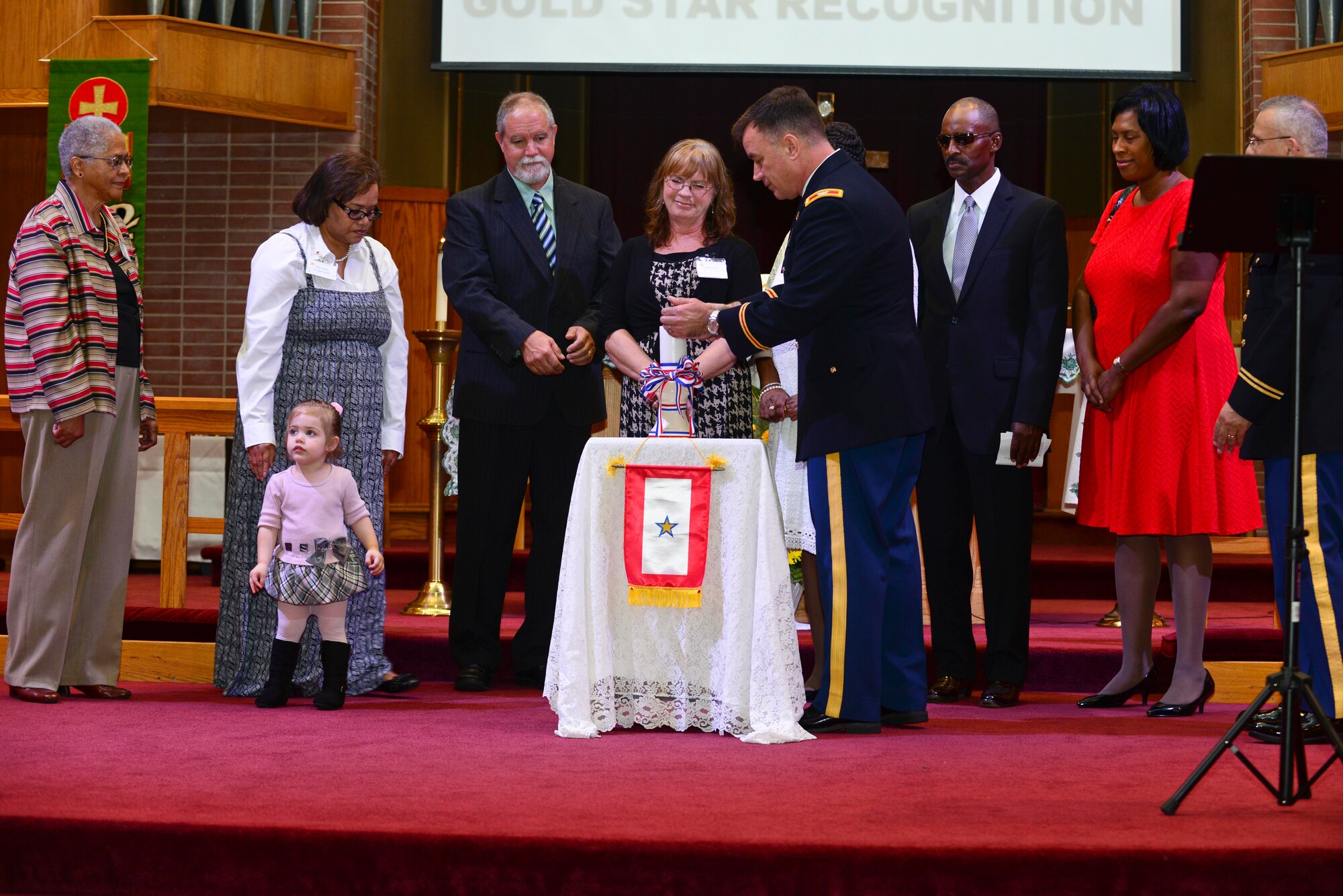 U.S. Army Col. William Galbraith, 733rd Mission Support Group commander, and Gold Star Family members, light a candle at the Gold Star Mother’s Day ceremony at the Regimental Memorial Chapel at Fort Eustis, Va., Sept. 28, 2014. The candle stayed lit during a church service held that morning in remembrance of the fallen Service members. (U.S. Air Force photo by Airman 1st Class Kimberly Nagle/Released)