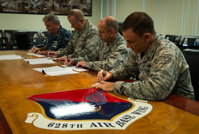 (Right to left) Col. John Lamontagne, 437th Airlift Wing commander, Col. Scott Sauter, 315th Airlift Wing commander, Col. Jeffrey DeVore, 628th Air Base Wing commander and Navy Capt. Timothy Sparks, 628th ABW deputy commander sign their donation slips for the Combined Federal Campaign Oct. 1, 2014, at the 628th ABW commander’s conference room on Joint Base Charleston, S.C. The CFC is a program designed to give all federal employees an opportunity to donate to eligible non-profit organizations which provide health and human service benefits throughout the world. The campaign will kick off Oct. 3 and last until Oct. 14. (U.S. Air Force photo/Airman 1st Class Clayton Cupit)