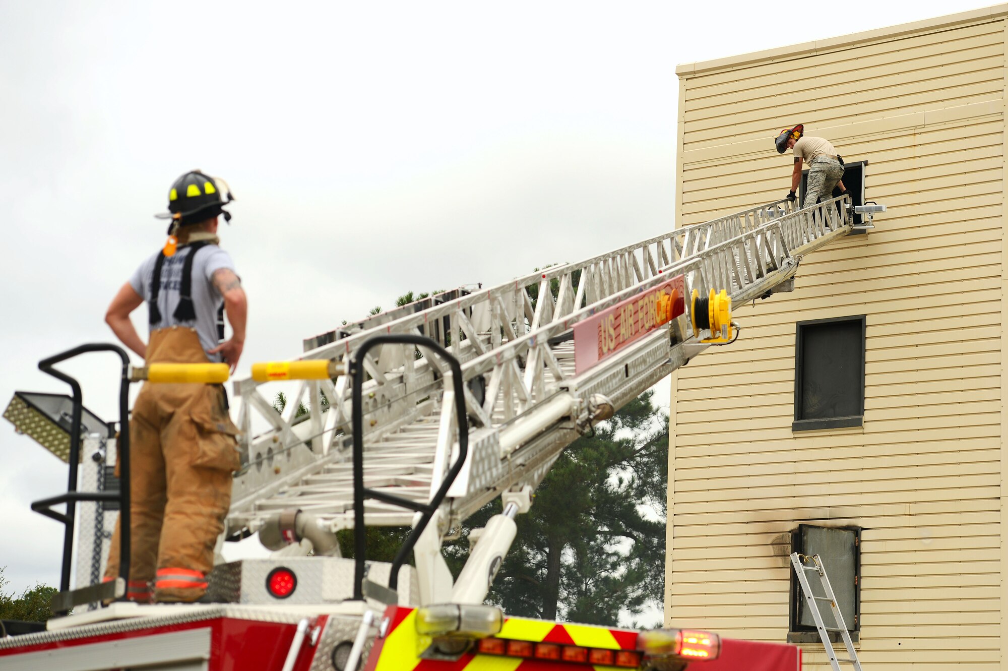 U.S. Air Force Staff Sgt. Micah Cook, 20th Civil Engineer Squadron firefighter, rests on a ladder after participating in live fire structural burn training at Shaw Air Force Base, S.C., Sept. 26, 2014. Due to temperatures that can reach up to 900 degrees in the structural burn tower, Airmen are advised to hydrate and rest after spending large amounts of time in the tower. (U.S. Air Force photo by Airman 1st Class Jensen Stidham/Released) 