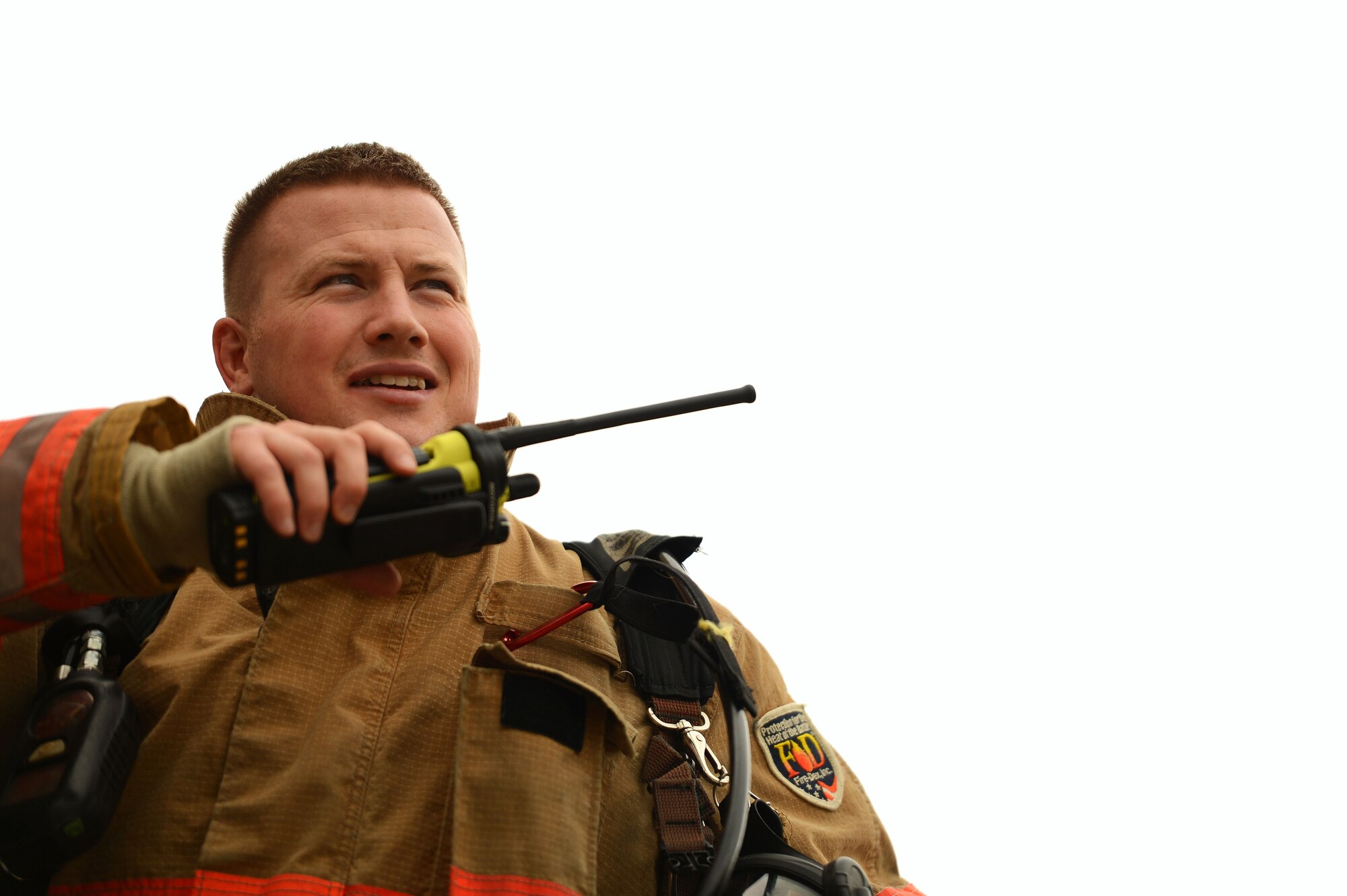U.S. Air Force Staff Sgt. Darin Meek, 20th Civil Engineer Squadron firefighter, speaks over a radio at Shaw Air Force Base, S.C., Sept. 26, 2014. Meek called the Shaw Fire Department to let them know the structural burn tower was ready for training. (U.S. Air Force photo by Airman 1st Class Jensen Stidham/Released)