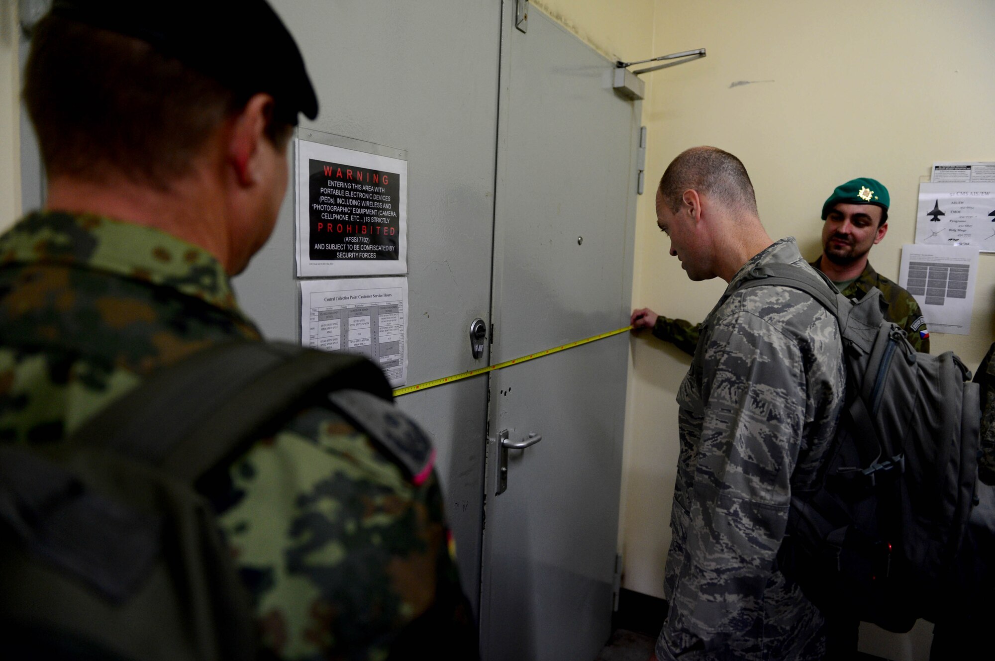 Inspectors from the Conventional Armed Forces in Europe treaty verification team measure an entrance door during an exercise at Spangdahlem Air Base, Germany, Sept. 29, 2014. Inspectors ensure treaty compliance by inspecting random buildings for excessive amounts of warfighting equipment. Inspectors maintain full access to any building with an entrance of two meters or greater in width. (U.S. Air Force photo by Airman 1st Class Kyle Gese/Released)