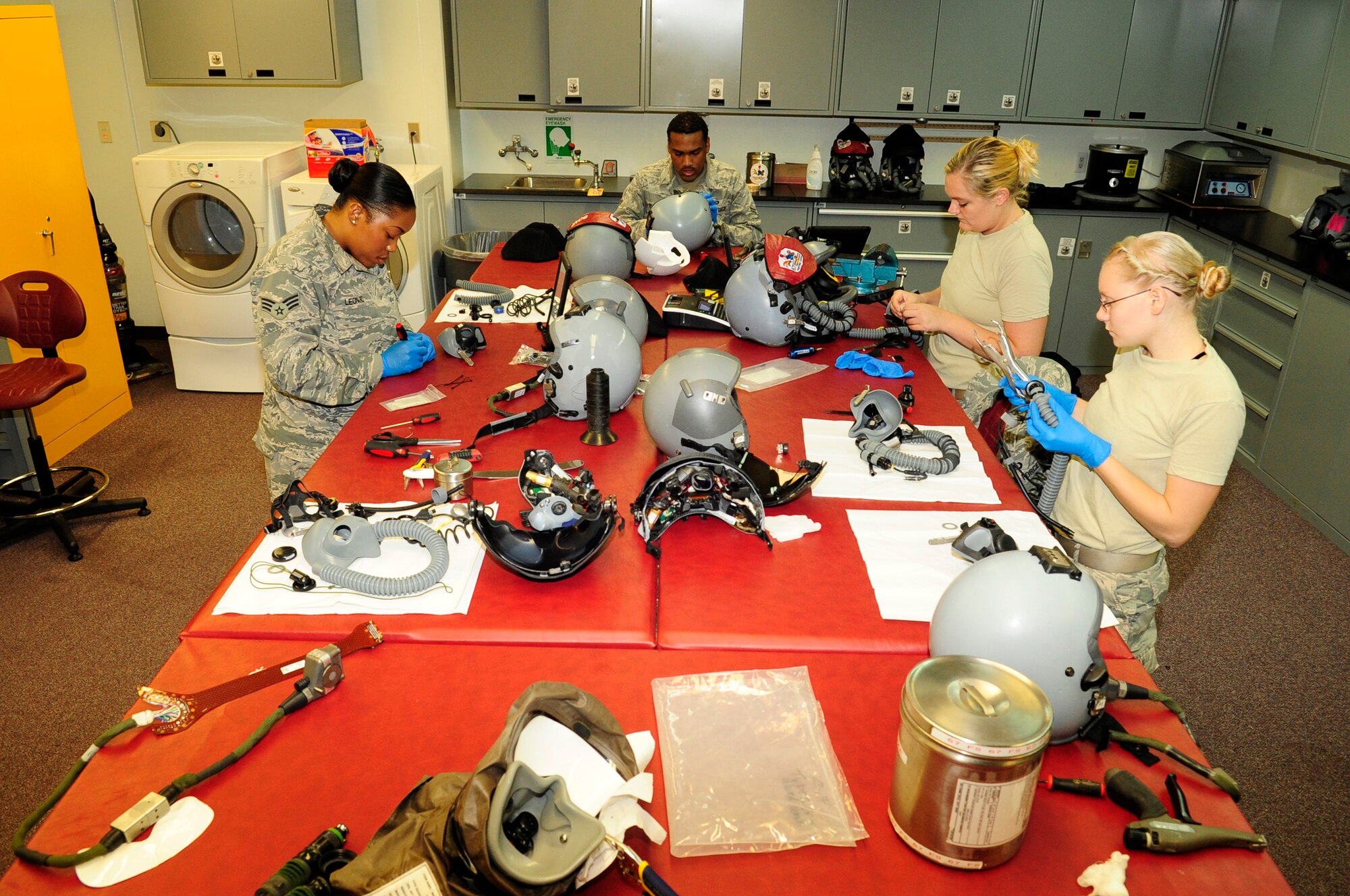 Members of the 18th Operations Support Squadron aircrew flight equipment shop work on joint helmeted mounted cueing systems, display units, breathing hoses, and helmets on Kadena Air Base, Japan, Sept. 30, 2014. The mission of the 18th OSS aircrew flight is to maintain all life saving equipment for all aircrew assigned to the 18th Wing. (U.S. Air Force photo by Airman 1st Class Keith James/Released)