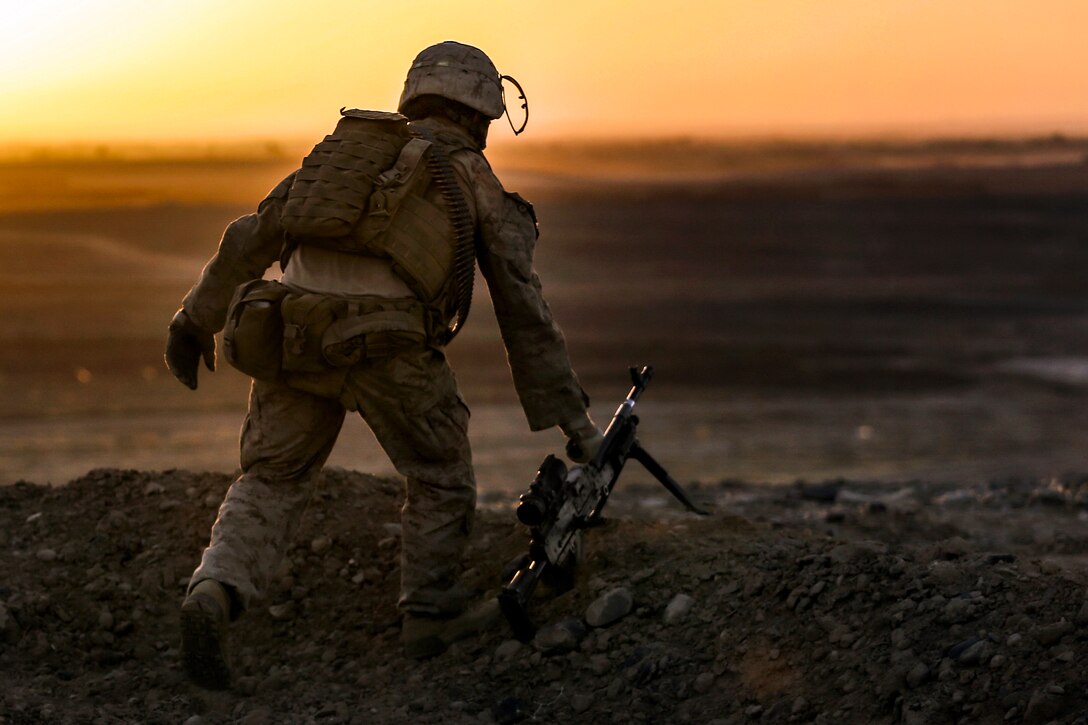 U.S. Marine Corps Cpl. Kevin Johnson sets an M240B machine gun down ...