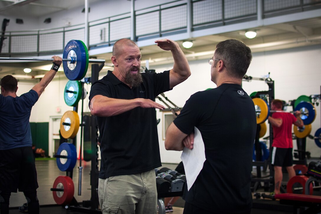 A soldier, right, consults with Mike Sanders, center, about his Combat Readiness Training Facility on Eglin Air Force Base, Fla., Sept. 20, 2014. The soldier is assigned to the 7th Special Forces Group. Sanders is responsible for the unit's Human Performance Program, an initiative combining the expertise of strength and conditioning coaches and physical therapists to maximize soldiers’ physical fitness.