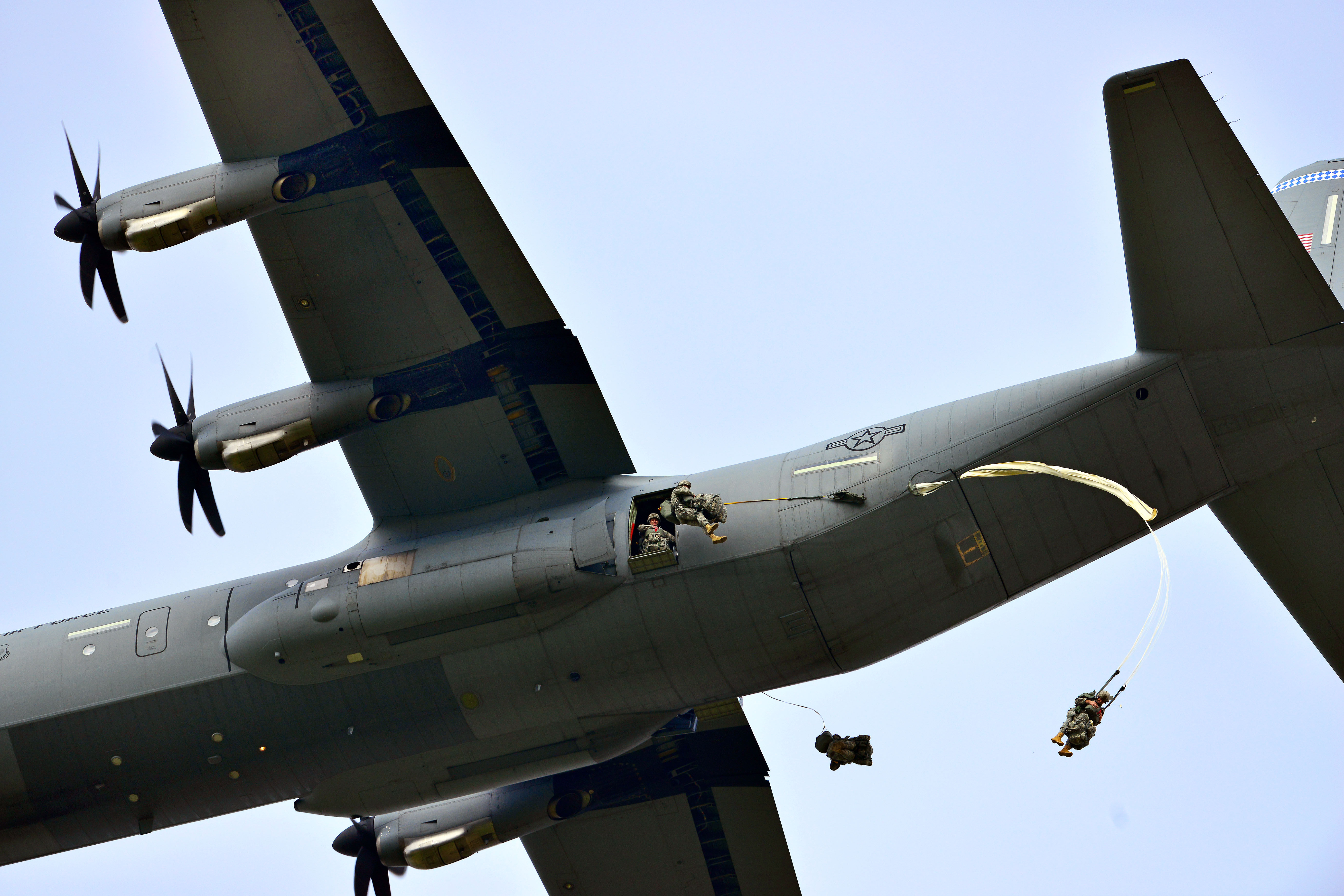 U.S. paratroopers utilizing T-11 parachutes conduct an airborne operation  from a C-130 Hercules aircraft