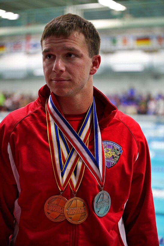 Marine Corps Cpl. Kyle Reid wears the three swimming medals he won during the Warrior Games at the U.S. Olympic Training Center in Colorado Springs, Colo., Sept. 30, 2014. Reid won gold medals in the 50-meter freestyle and 100-meter freestyle, and took the silver medal in the 50-meter backstroke.