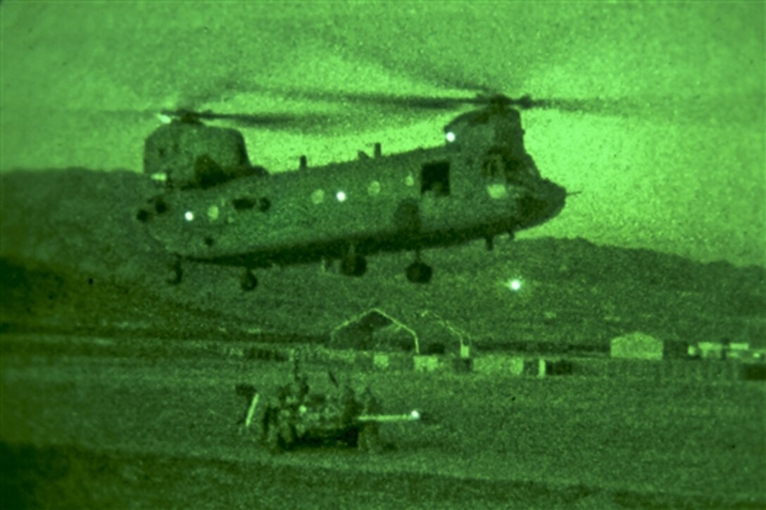 As seen through a night-vision device, U.S. soldiers prepare to hook an M777A2 weapon system to a CH-47 Chinook helicopter during slingload operations on Forward Operating Base Lightning in Afghanistan's Paktya province, Sept. 24, 2014. The mission is part of an ongoing retrograde on Forward Operating Base Lightning. The soldiers are assigned to Field Artillery Squadron, 3rd Cavalry Regiment.