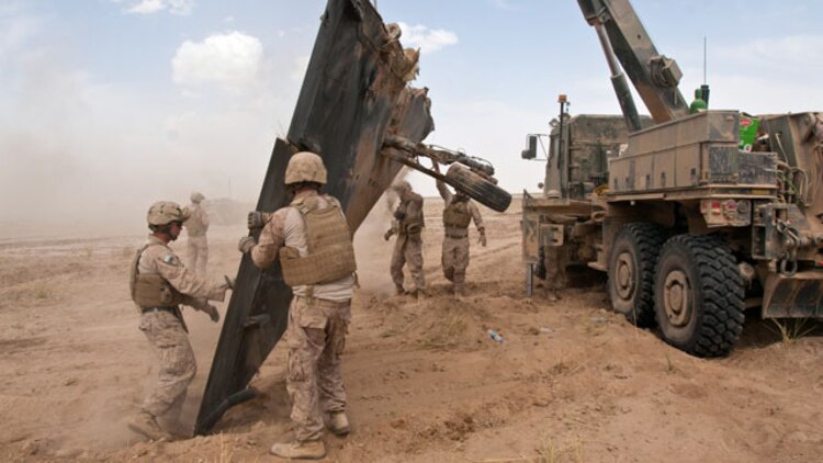 U.S. Marines use an MK36 Medium Tactical Vehicle Replacement (MTVR) truck to hoist the wing section of a downed Mirage 2000-5F aircraft during salvage operations in the province of Helmand, Afghanistan, May 25, 2011. The Marines are assigned to Combat Logistics Group 8, 2nd Marine Logistics Group. (U.S. Marine Corps photo by Staff Sgt. Jeff Kaus/Released)