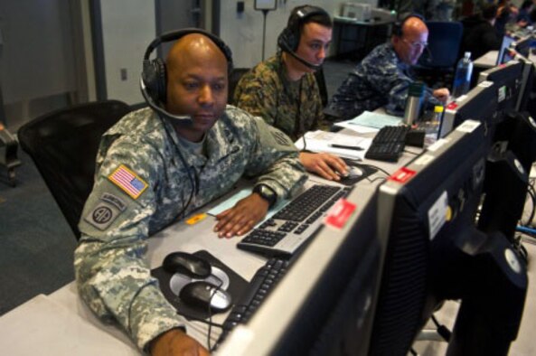 Army Chief Warrant Officer 2 Michael Lyons, Joint Tactical Communications Office communications operator from Fort Sam Houston, Texas, looks through information on a workstation inside the Combined Air and Space Operations Center-Nellis during Red Flag 14-1, Feb. 5, 2014, at Nellis Air Force Base, Nev. This is the first exercise that truly integrates advanced operational and tactical air, space and cyber training in a live, virtual, constructive environment. (U.S. Air Force photo/Senior Airman Brett Clashman)