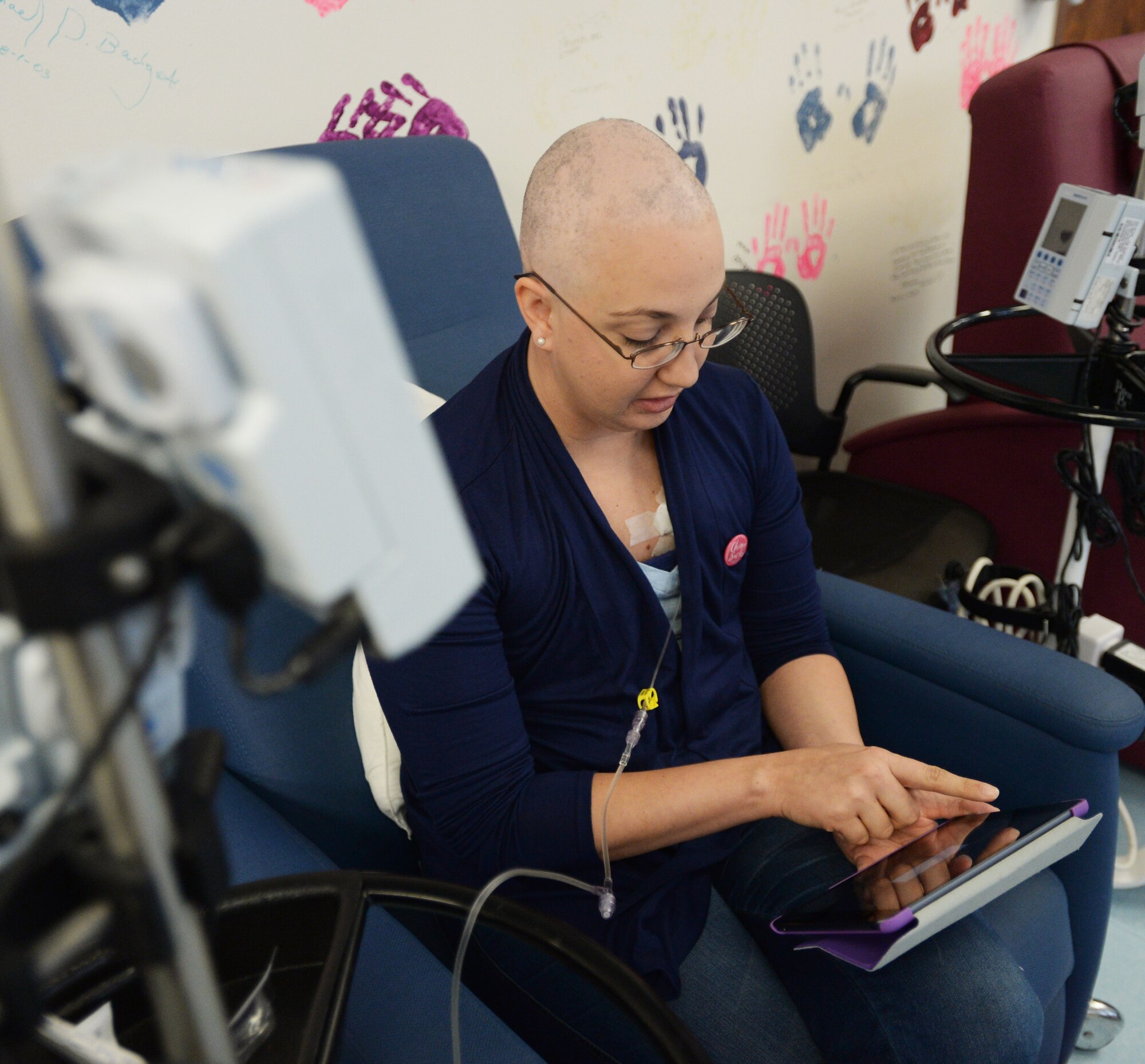 Staff Sgt. Amanda Dick, 15th Medical Support Squadron patient flight, reads an eBook during her chemotherapy treatment at Tripler Army Medical Center in Honolulu, Hawaii, Feb. 26, 2014. Since being diagnosed with breast cancer in October 2013, Dick has finished one of two rounds of chemotherapy, and is expected to be done with treatment in April. (U.S. Air Force photo/Staff Sgt. Alexander Martinez)