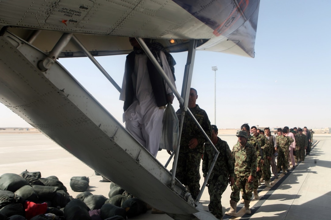 Afghan National Army soldiers with the 215th Corps and Afghan civilians board an aircraft aboard Camp Bastion, Helmand province, Afghanistan, Sept. 27, 2014. The soldiers and civilians are planning to travel to Kabul for a rest and relaxation period with their families. (U.S. Marine Corps photo by Cpl. Cody Haas/ Released)