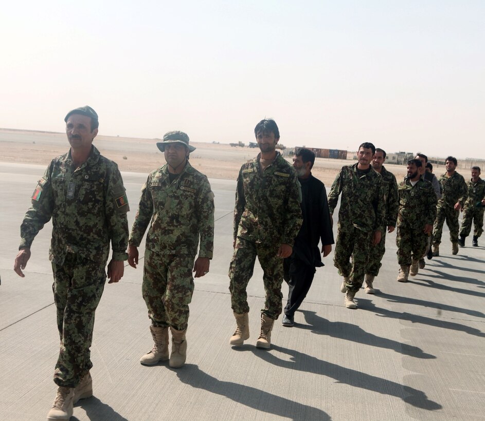 Afghan National Army soldiers with the 215th Corps and Afghan civilians walk in a single-file line while boarding an aircraft aboard Camp Bastion, Helmand province, Afghanistan, Sept. 27, 2014. The soldiers and civilians are planning to travel to Kabul for a rest and relaxation period with their families. (U.S. Marine Corps photo by Cpl. Cody Haas/ Released)