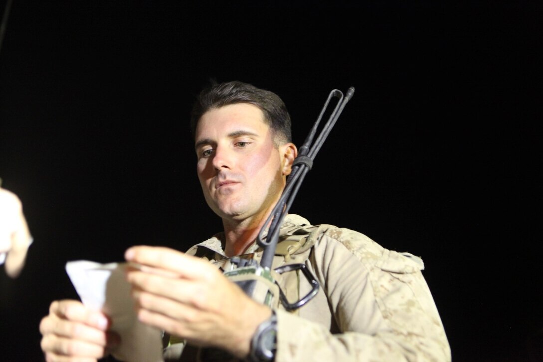 Sergeant Dominic Sharpsteensurina, a native of Apple Valley, California, and an assault section leader with Weapons Platoon, Charley Company, 1st Battalion, 7th Marine Regiment, inspects an information card aboard Camp Dwyer, Helmand province, Afghanistan, Sept. 21, 2014. During his current deployment in Afghanistan, Sharpsteensurina was meritoriously promoted to the rank of sergeant. He is glad to be able to take part in Operation Enduring Freedom with his fellow infantrymen and become someone they can look up to. (U.S. Marine Corps photo by Cpl. Cody Haas/ Released)