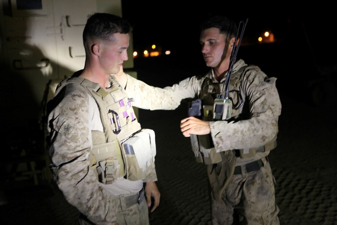 Sergeant Dominic Sharpsteensurina, right, a native of Apple Valley, California, and an assault section leader with Weapons Platoon, Charley Company, 1st Battalion, 7th Marine Regiment, inspects Lance Cpl. Jordan Pettid, a squad leader with Weapons Plt., aboard Camp Dwyer, Helmand province, Afghanistan, Sept. 21, 2014. During his current deployment in Afghanistan, Sharpsteensurina was meritoriously promoted to the rank of sergeant. He is glad to be able to take part in Operation Enduring Freedom with his fellow infantrymen and become someone they can look up to. (U.S. Marine Corps photo by Cpl. Cody Haas/ Released)