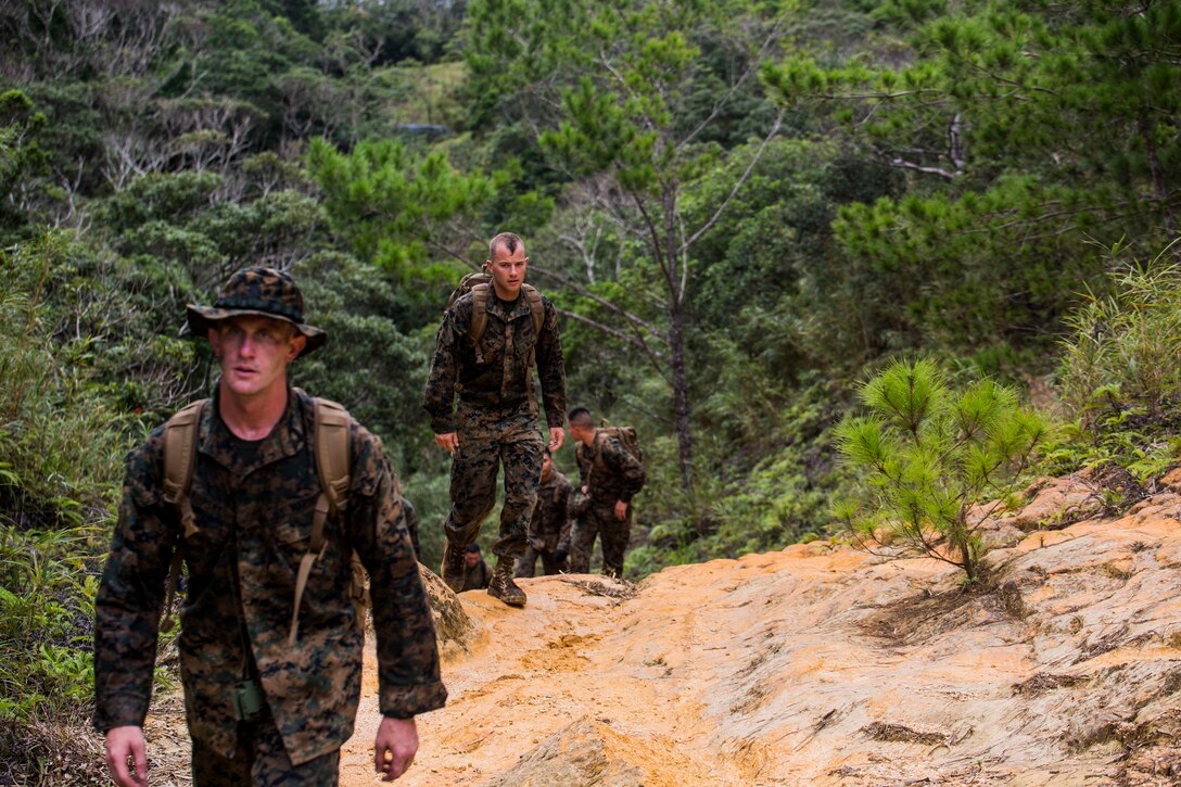 Marines participating in a Corporals Course locate points on a map Sept. 23 during a land navigation course at the Jungle Warfare Training Center, Camp Gonsalves. Due to the jungles thick vegetation and uneven terrain, the corporals had to recognize land developments by looking at contour lines to determine elevation while orientating the map with the environment around them. The Marines are with various units across III Marine Expeditionary Force. (U.S. Marine Corps photo by Lance Cpl. Ryan C. Mains/Released)