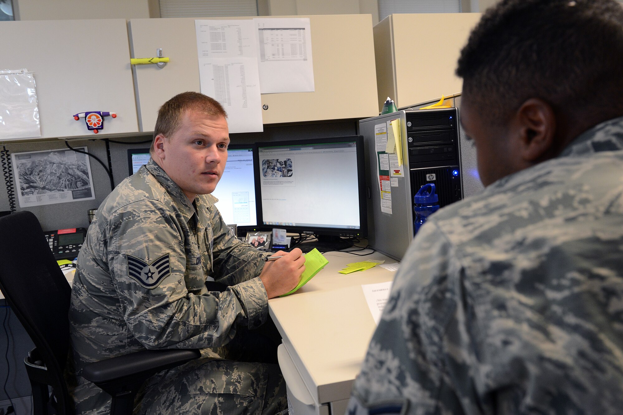 Staff Sgt. Devon Cross (left), 62nd Comptroller Squadron budget analysis, reviews financial documents with Airman 1st Class Alando McGreggor, 62nd CPTS budget analysis, during end-of-year closeout Sept. 30, 2014, at Joint Base Lewis-McChord, Wash. Prior to starting a new fiscal year, finance Airmen have to ensure Air Force financial accounts are properly balanced. (U.S. Air Force photo/Airman 1st Class Jacob Jimenez)