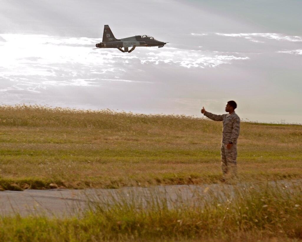 Senior Airman Markus Beach from the 80th Flying Training Wing gives a thumbs up as the pilots in the T-38 Talon prepare to takeoff for a sortie Oct. 2, 2014 at Sheppard Air Force Base, Texas. (U.S. Air Force photo by Danny Webb/Released) 