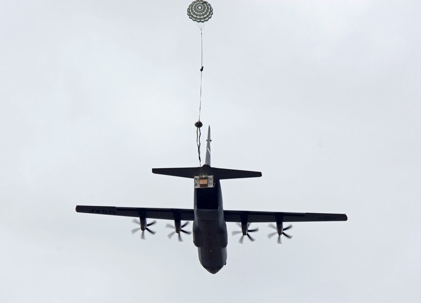A parachute pulls equipment out of a U.S. Air Force C-130J Super Hercules assigned to the 317th Airlift Group Sept. 26, 2014, at Dyess Air Force Base, Texas. Before departing from the local area, aircrews competed against one another to test their airdrop capabilities. This form of training allowed aircrews to drop multiple types of equipment at Dyess’ drop zone. (U.S. Air Force photo by Senior Airman Peter Thompson/Released)