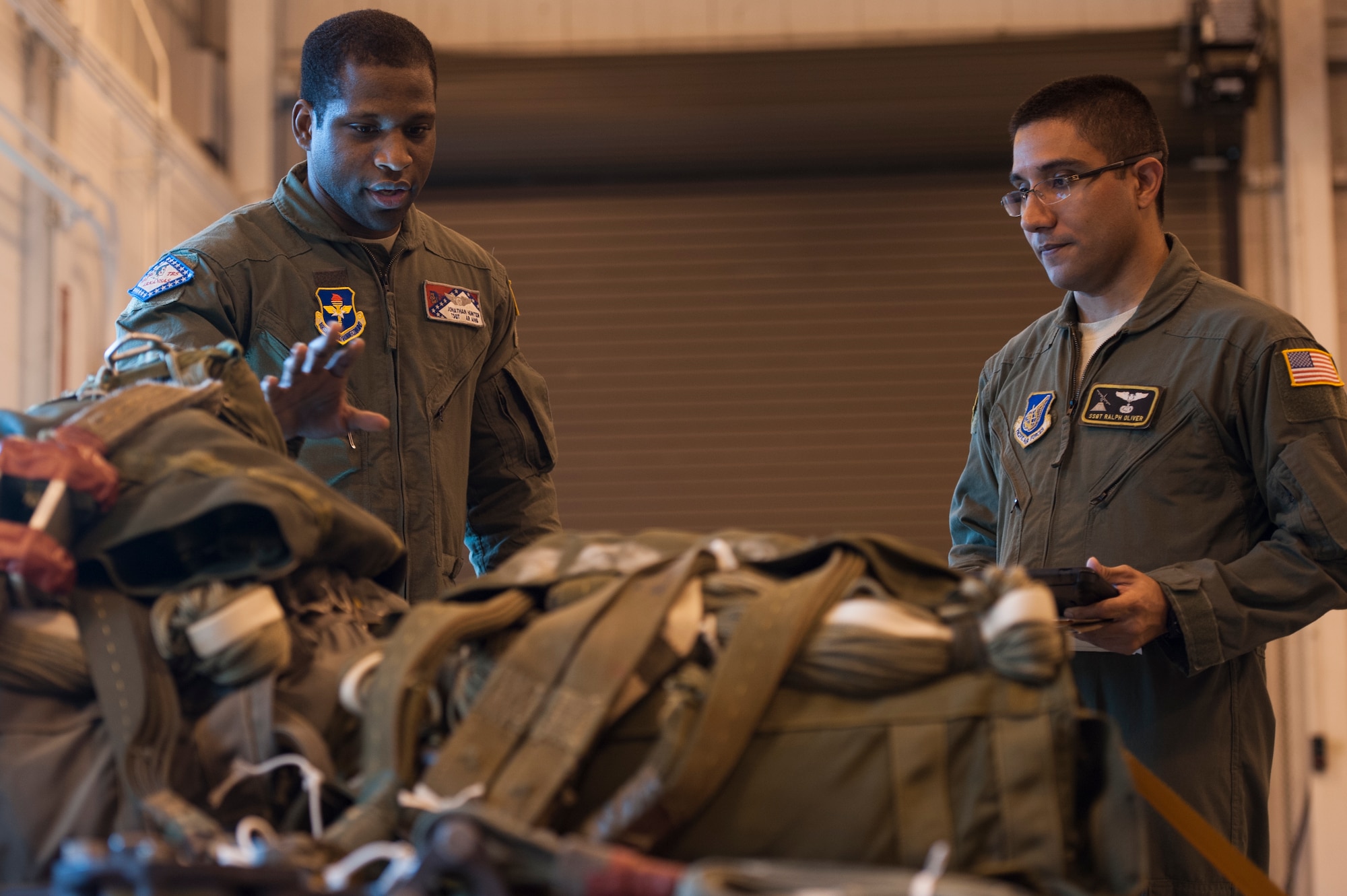 Tech. Sgt. Jonathan Hunter, a 189th Airlift Wing C130H formal training unit instructor and joint airdrop inspector loadmaster, explains teaching techniques to Staff Sgt. Ralph Oliver, a 36th Airlift Squadron loadmaster, Sept. 30, 2014, at Little Rock Air Force Base, Ark. Hunter instructs Department of Defense  and international students for initial training and instructor qualification. (U.S. Air Force photo by Senior Airman Kaylee Clark)
