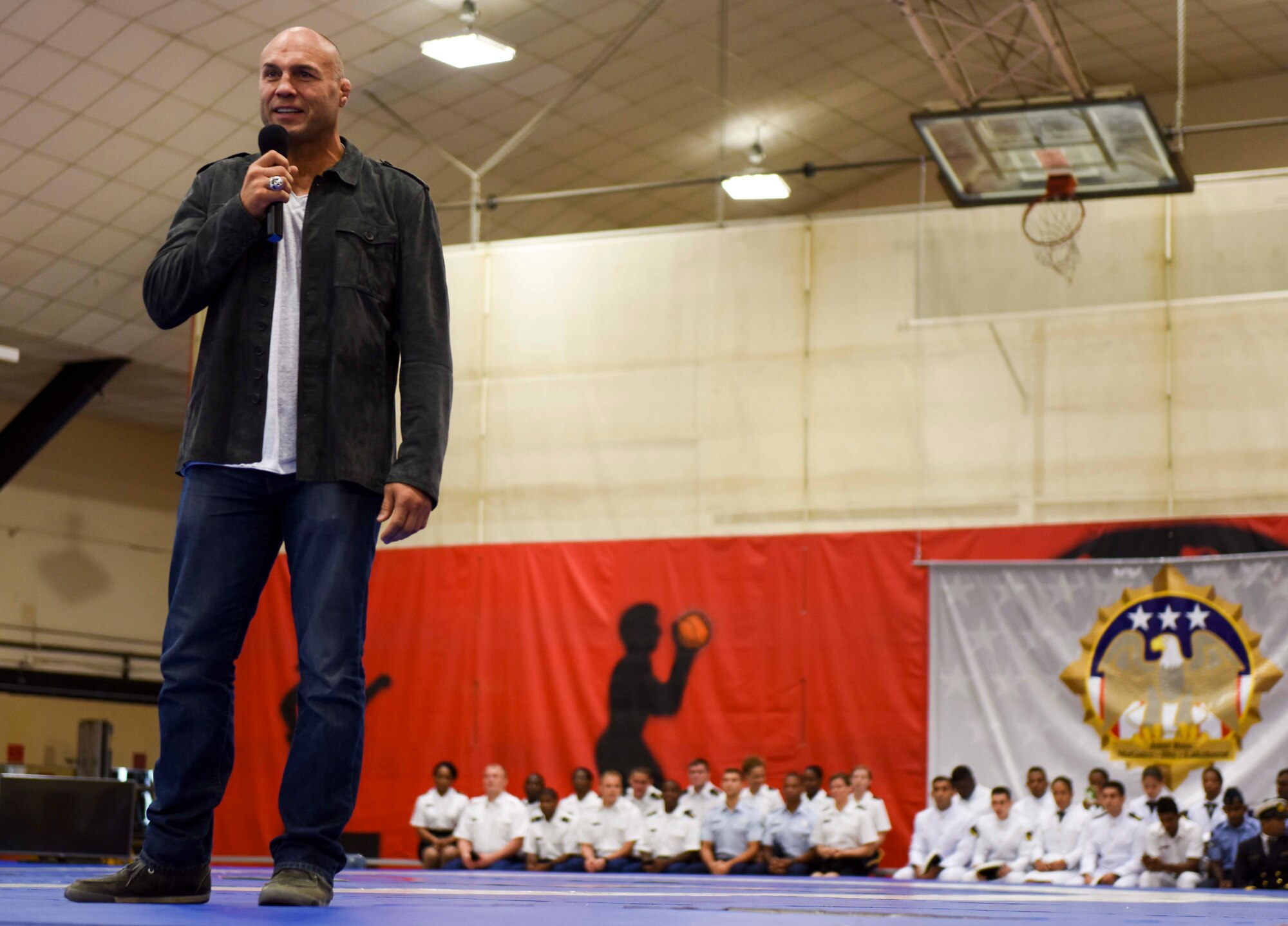 Randy Couture, five-time Ultimate Fighting Championship title-holder, takes the floor at the CISM World Wrestling Competition opening ceremony Oct. 2, 2014, in the Griffith Field House at Joint Base McGuire-Dix-Lakehurst, N.J. Today’s CISM World Wrestling Competition opening ceremony welcomed 340 delegates from 24 countries for the upcoming week-long competition. Wrestlers from Algeria, Armenia, Brazil, China, Egypt, Estonia, Finland, Germany, India, Italy, Kazakhstan, Latvia, Lithuania, Mongolia, Morocco, Pakistan, Poland, Slovakia, Slovenia, Sri Lanka, Switzerland, United Arab Emirates, Ukraine and the United States will compete in freestyle and Greco Roman wrestling until Oct. 7. For a complete list of events during the competition, click here. All DOD ID cardholders are welcome to attend. (U.S. Air Force photo by Senior Airman Ryan Throneberry/Released)