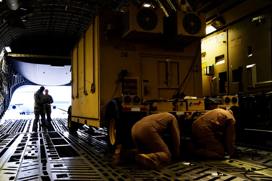 JOINT BASE MCGUIRE-DIX-LAKEHURST, N.J. - Airmen from the 621st Contingency Response Wing and 15th Airlift Squadron, assigned to Joint Base Charleston, N.C., load a CRW Hard-side Expandable Light Air-Mobile Shelter (HELAMS) onto a Globemaster III C-17, also from JB Charleston, here, Sept. 29, 2014. The HELAMS will be used by the 621 CRW in West Africa in support of Operation UNITED ASSISTANCE in response to the Ebola virus disease outbreak. The CRW is highly-specialized in training and rapidly deploying personnel to quickly open airfields and establish, expand, sustain, and coordinate air mobility operations. From wartime taskings to disaster relief, the CRW extends Air Mobility Command's reach in deploying people and equipment around the globe. (U.S. Air Force photo by Staff Sgt. Gustavo Gonzalez/Released)