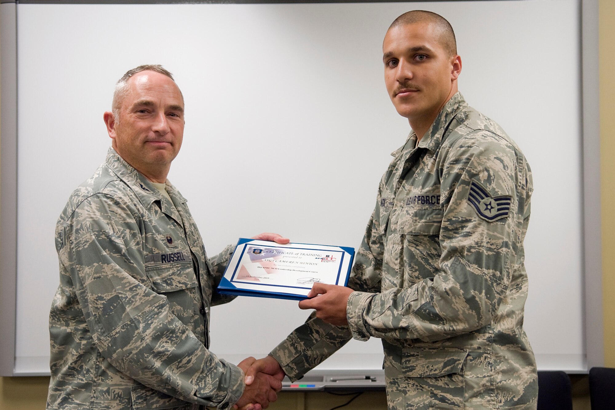 Col. Scott Russell, 434th Mission Support Group commander, left, presents Staff Sgt. Cameren Hinton, 434th Maintenance Squadron aircraft fuel systems journeyman, with a certificate of completion from an Air Force Reserve Noncommissioned Officer Leadership Development Course at Grissom Air Reserve Base, Ind., Sept. 19, 2014. The 10-day course combined college level management and leadership instruction with a military practical, experimental and hands-on application. (U.S. Air Force photo/Mark R. W. Orders-Woempner)

