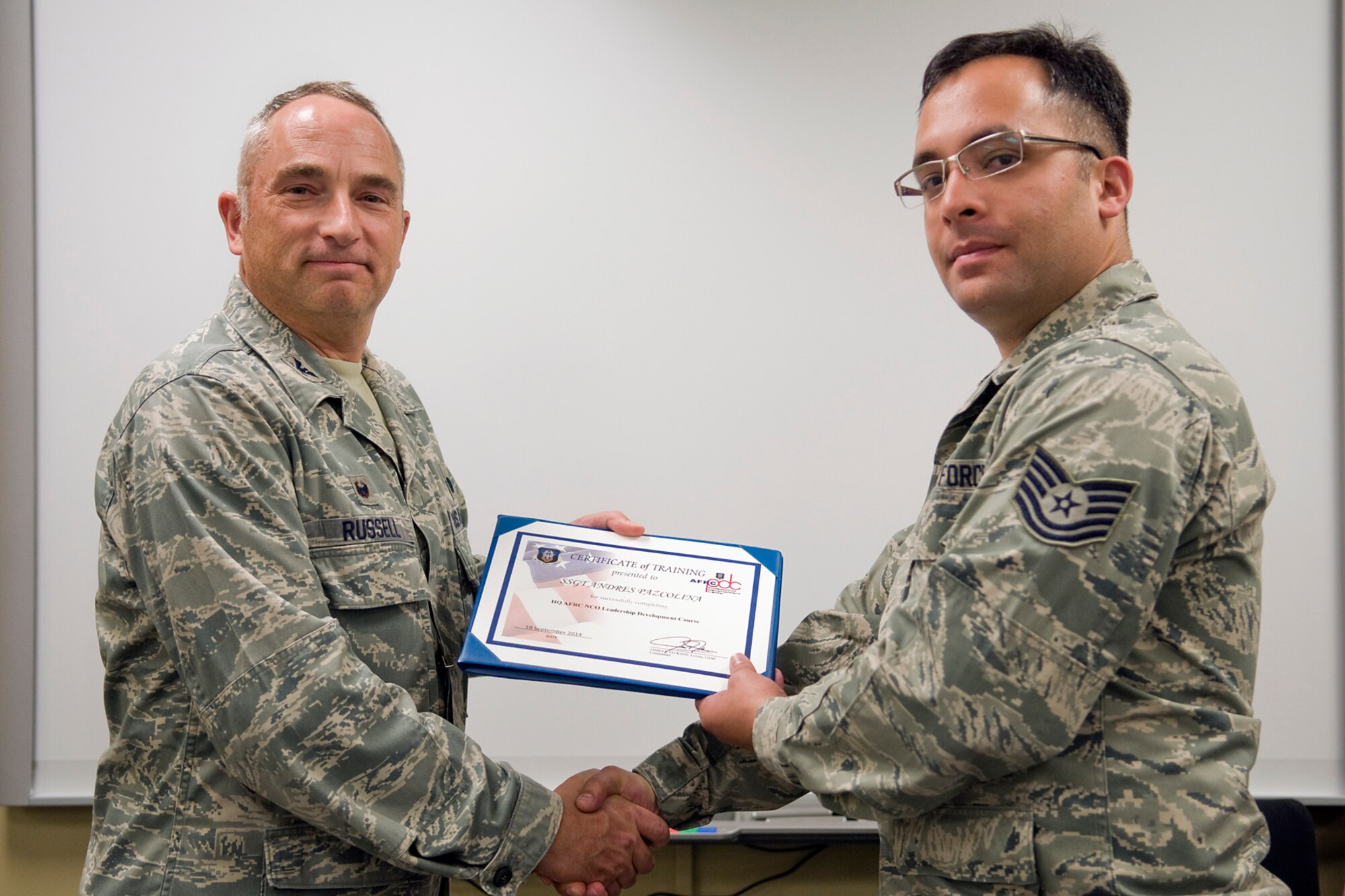 Col. Scott Russell, 434th Mission Support Group commander, left, presents Staff Sgt. Andres Paz-Colina, 434th Logistics Readiness Squadron fuels craftsman, with a certificate of completion from an Air Force Reserve Noncommissioned Officer Leadership Development Course at Grissom Air Reserve Base, Ind., Sept. 19, 2014. The 10-day course combined college level management and leadership instruction with a military practical, experimental and hands-on application. (U.S. Air Force photo/Mark R. W. Orders-Woempner)

