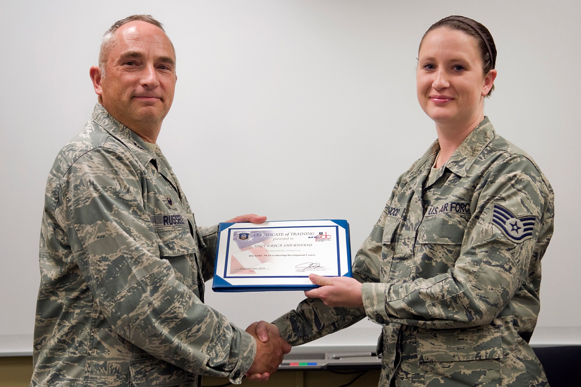 Col. Scott Russell, 434th Mission Support Group commander, left, presents Staff Sgt. Erica Sherwood,434th Force Support Squadron career development assistant chief, with a certificate of completion from an Air Force Reserve Noncommissioned Officer Leadership Development Course at Grissom Air Reserve Base, Ind., Sept. 19, 2014. The 10-day course combined college level management and leadership instruction with a military practical, experimental and hands-on application. (U.S. Air Force photo/Mark R. W. Orders-Woempner)
