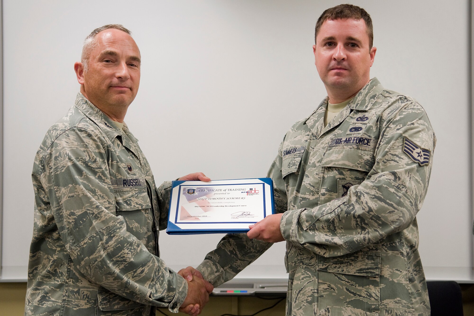 Col. Scott Russell, 434th Mission Support Group commander, left, presents Staff Sgt. Timothy Sommers, 434th Security Forces Squadron security forces team members, with a certificate of completion from an Air Force Reserve Noncommissioned Officer Leadership Development Course at Grissom Air Reserve Base, Ind., Sept. 19, 2014. The 10-day course combined college level management and leadership instruction with a military practical, experimental and hands-on application. (U.S. Air Force photo/Mark R. W. Orders-Woempner)
