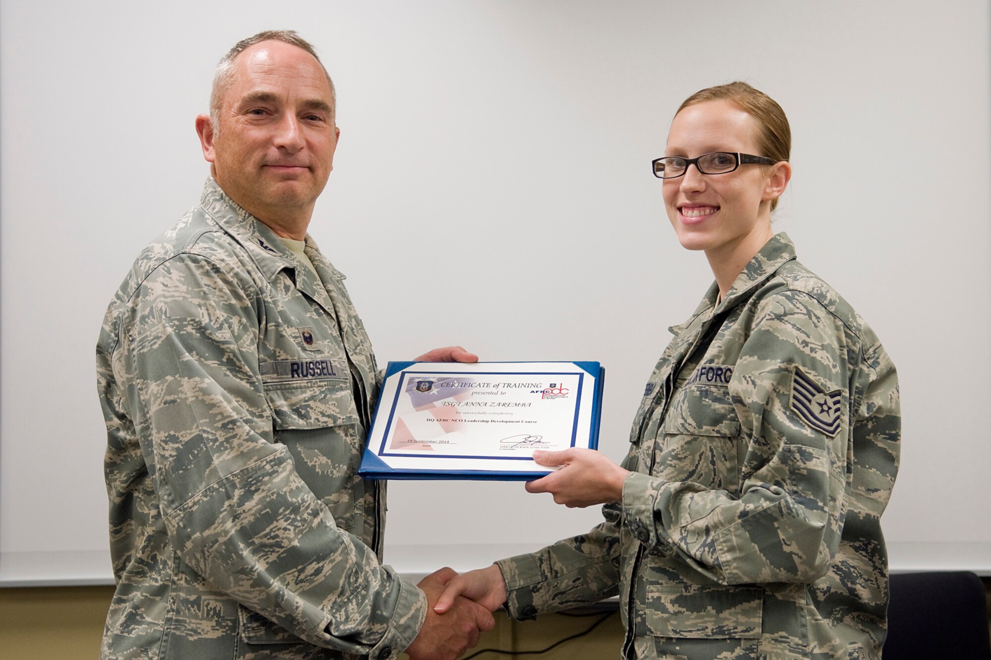 Col. Scott Russell, 434th Mission Support Group commander, left, presents Tech. Sgt Anna Zaremba, 434th Aerospace Medicine Squadron medical lab technician, with a certificate of completion from an Air Force Reserve Noncommissioned Officer Leadership Development Course at Grissom Air Reserve Base, Ind., Sept. 19, 2014. The 10-day course combined college level management and leadership instruction with a military practical, experimental and hands-on application. (U.S. Air Force photo/Mark R. W. Orders-Woempner)
