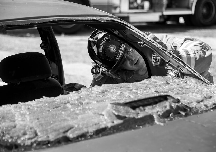 A 96th Test Wing examines the best way to cut into the car’s roof during an extraction training exercise at Duke Field, Fla., Sept. 10.  The day crew of Fire Station 4 took part in the exercise to meet their training requirement.  National Fire Prevention Week began Oct. 5.  Eglin firefighters have various activities planned throughout the week.   (U.S. Air Force photo/Tech. Sgt. Sam King)