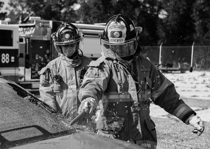 A 96th Test Wing firefighter breaks out the rear car window during an extraction training exercise at Duke Field, Fla., Sept. 10.  The day crew of Fire Station 4 took part in the exercise to meet their training requirement.  National Fire Prevention Week began Oct. 5.  Eglin firefighters have various activities planned throughout the week.   (U.S. Air Force photo/Tech. Sgt. Sam King)