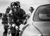 A 96th Test Wing firefighter inserts a wedge tool to begin prying open the car door during an extraction training exercise at Duke Field, Fla., Sept. 10.  The day crew of Fire Station 4 took part in the exercise to meet their training requirement.  National Fire Prevention Week began Oct. 5.  Eglin firefighters have various activities planned throughout the week.   (U.S. Air Force photo/Tech. Sgt. Sam King)
