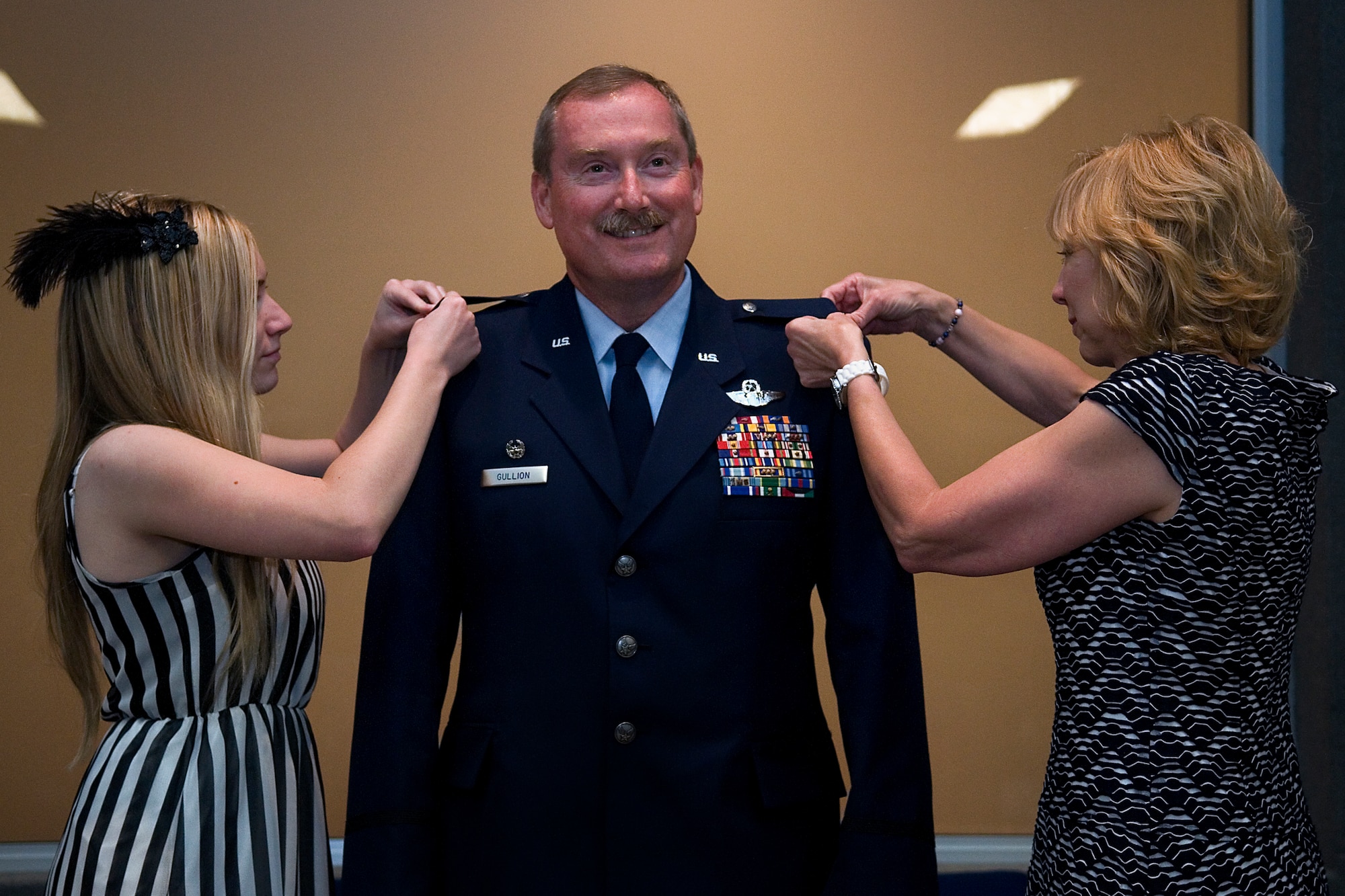 Col. Douglas Gullion, 434 Operations Support Squadron commander, has his wife, Pam, right, and daughter, Haleigh, left, pin eagle rank insignias on his service dress coat during a during a pin-on ceremony at Grissom Air Reserve Base, Ind., Sept. 7, 2014. Gullion is expected to assume the new role as commander of the 507th Operations Group, Tinker Air Force Base, Okla. Nov. 2, 2014. (U.S. Air Force photo/Senior Airman Jami Lancette)