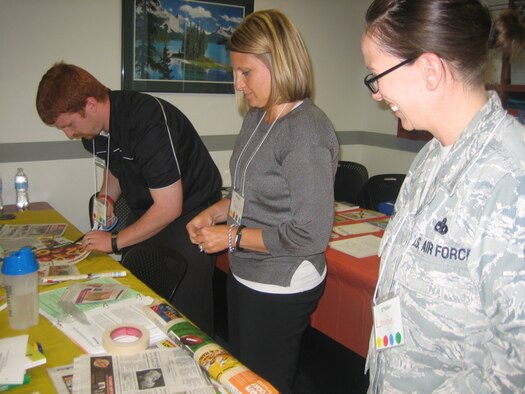 Travis Apling, 92nd Force Support Squadron Teen Center, Janna Keller, 92nd FSS Airman and Family Readiness Center services consultant, and Master Sgt. Laurie Simons, 92nd FSS A&FRC superintendent, work on a project during True Colors training Sept. 15, 2014, at Fairchild Air Force Base, Washington. The training is based on a personality identification model, to help unit members understand personalities. (Courtesy photo)