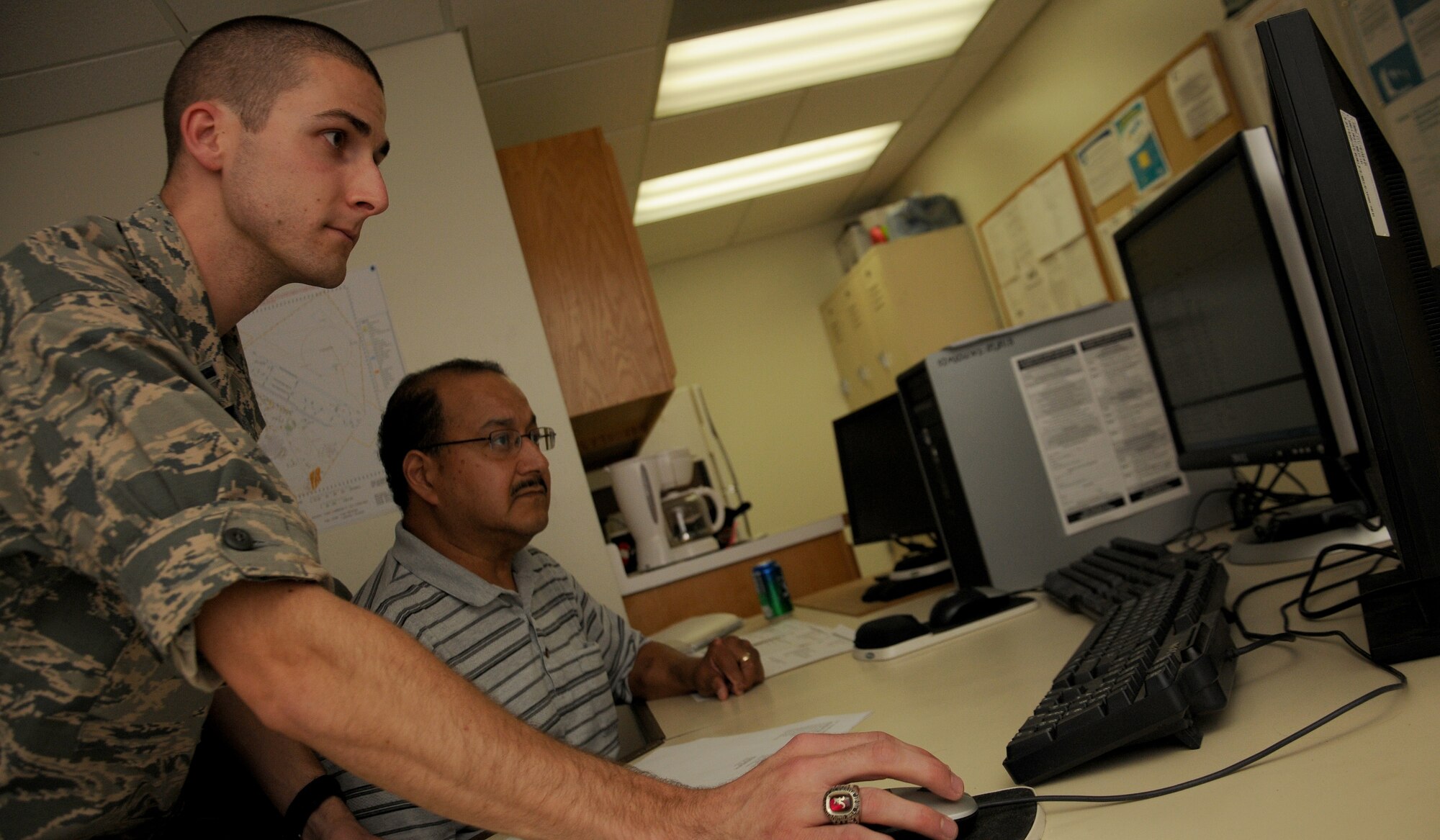 1st Lt. Charles Heim, front, 47th Civil Engineering Squadron energy management officer in charge, and Matias Aguilera, 47th CES energy manager, review a map of Laughlin’s facilities with current building temperatures Sept. 4, 2014 at Laughlin Air Force Base, Texas. Energy management monitors the temperature of Laughlin’s facilities to ensure that not only energy is being conserved but personnel can work comfortably and equipment can work properly. (U.S. Air Force photo by Airman 1st Class Ariel D. Delgado)(Released)
