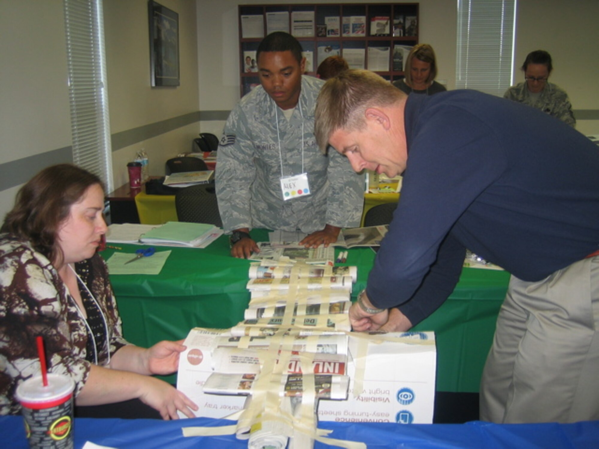 Sharon Lisby, 92nd Force Support Squadron Airman and Family Readiness Center consultant, Staff Sgt. Alex Montes, 92nd Air Refueling Wing photojournalist and Jim O'Connell, 92nd ARW historian, work on a project together during True Colors training at Fairchild Air Force Base, Washington, Sept. 15, 2014. The training for True Colors is a way for people to understand each other, communicate, embrace diversity and maximize differences in aiding the mission and combatant commanders. The training was held Sept. 15 to 17 at the A&FRC. (Courtesy Photo)