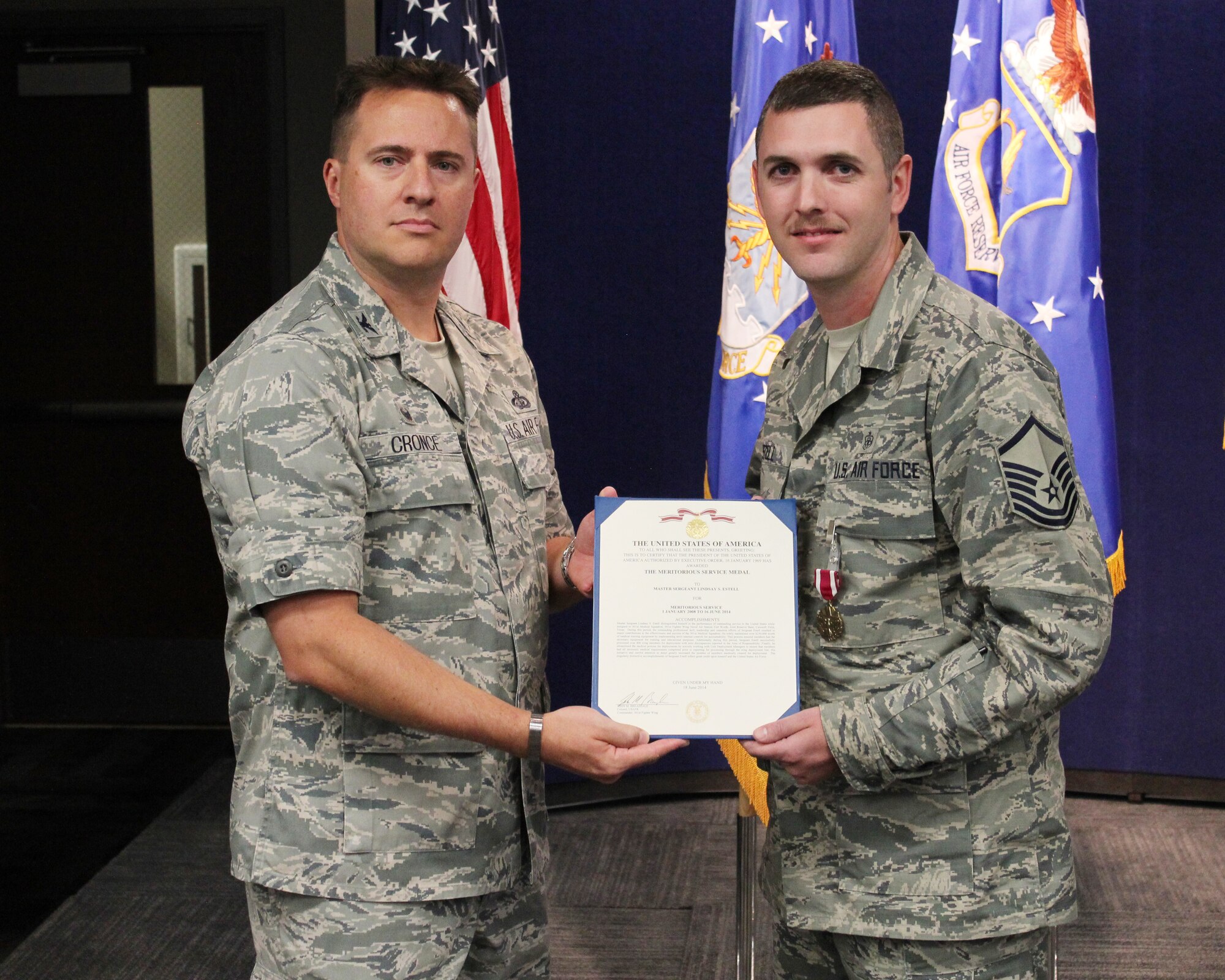 Col. Chistopher Cronce, Headquarters Individual Reservist Readiness and Integration Organization commander, presents Master Sgt. Lindsay Estell, HQ RIO medical, with a Meritorious Service Medal during the firstfirst HQ RIO commander's call at the Air Reserve Personnel Center. (Photo by Master Sgt. Timm Huffman)