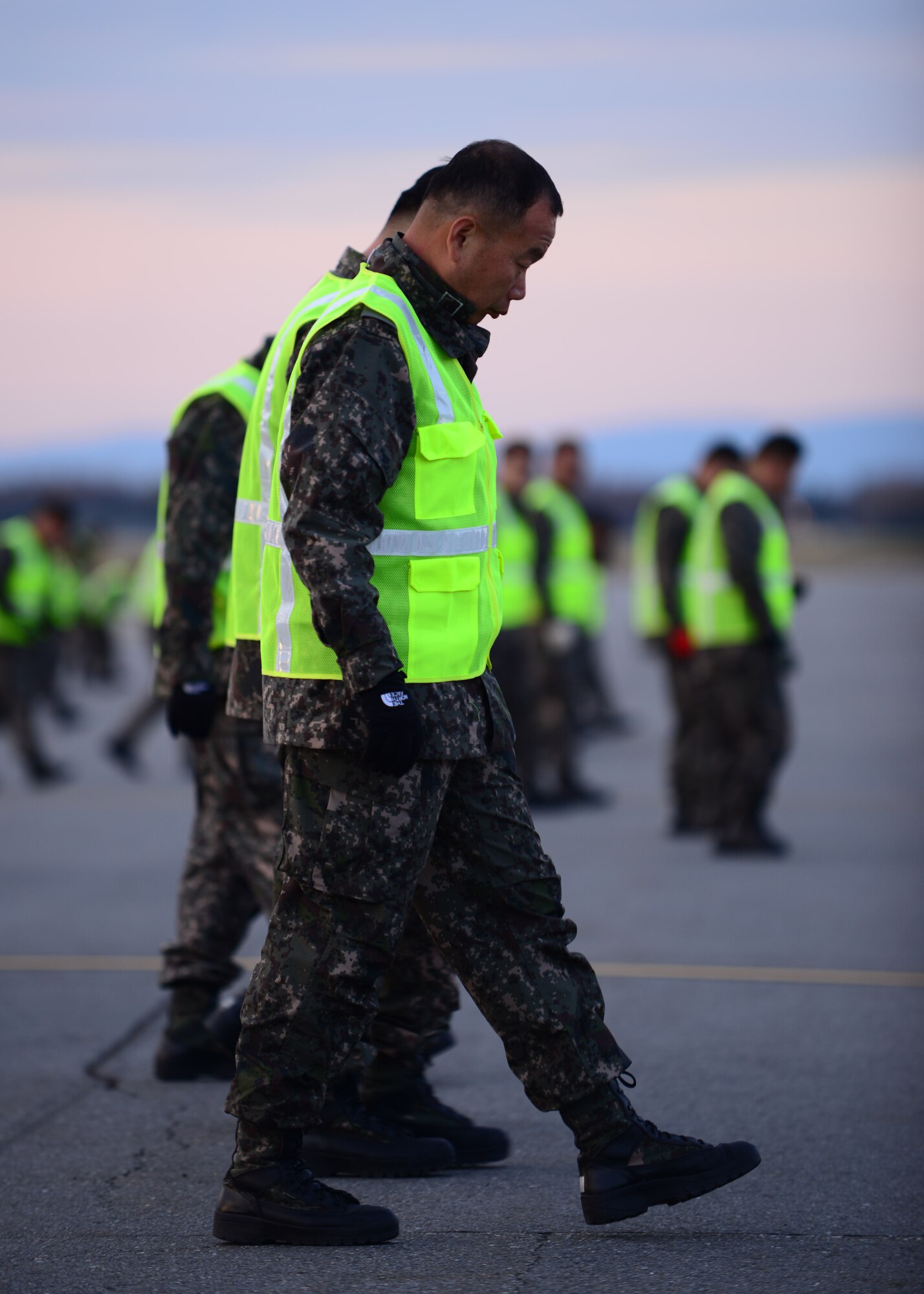 Republic of Korea air force Warrant Officer Myung Hwan Choi, a maintainer assigned to the 20th Fighter Wing, performs a foreign object debris walk with other members of the ROKAF Red Flag team Sept. 24, 2014, Eielson Air Force Base, Alaska. The ROKAF Red Flag team members prepared for the arrival of their F-16 Fighting Falcon fighter aircraft, which made their first trip across the Pacific Ocean. (U.S. Air Force photo by Senior Airman Ashley Nicole Taylor/Released)