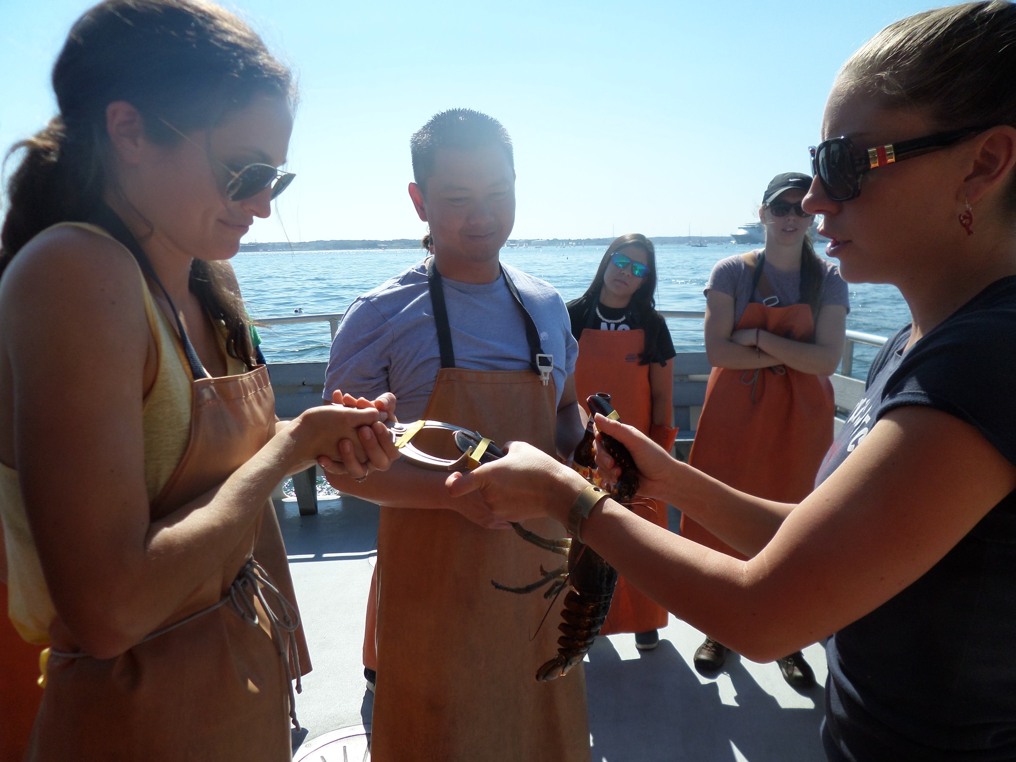 U.S. Air Force Capts. Julie Anderson, a Hanscom AFB dentist, and Dennis Wu, from the base legal office, band a freshly caught lobster during a Junior Force Council lobstering trip to Portland, Maine, Sept. 27. (U.S. Air Force photo by Jeff Price)
