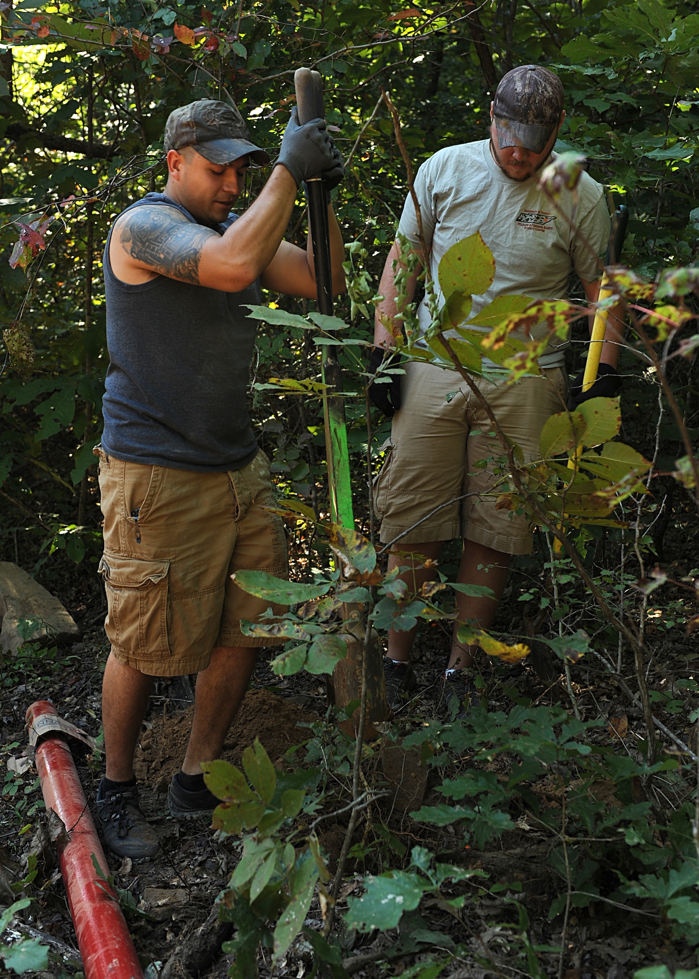 Airman 1st Class Scott Poe, a 19th Airlift Wing Public Affairs photojournalist, and another volunteer dig post holes Sept. 27, 2014, at Bearcat Hollow Wildlife Management Area in Northwest Arkansas. Airmen and other volunteers built gates, planted winter wheat, cleared fields of debris and cleaned up streams to attract and protect wildlife living in the area. (Courtesy photo)