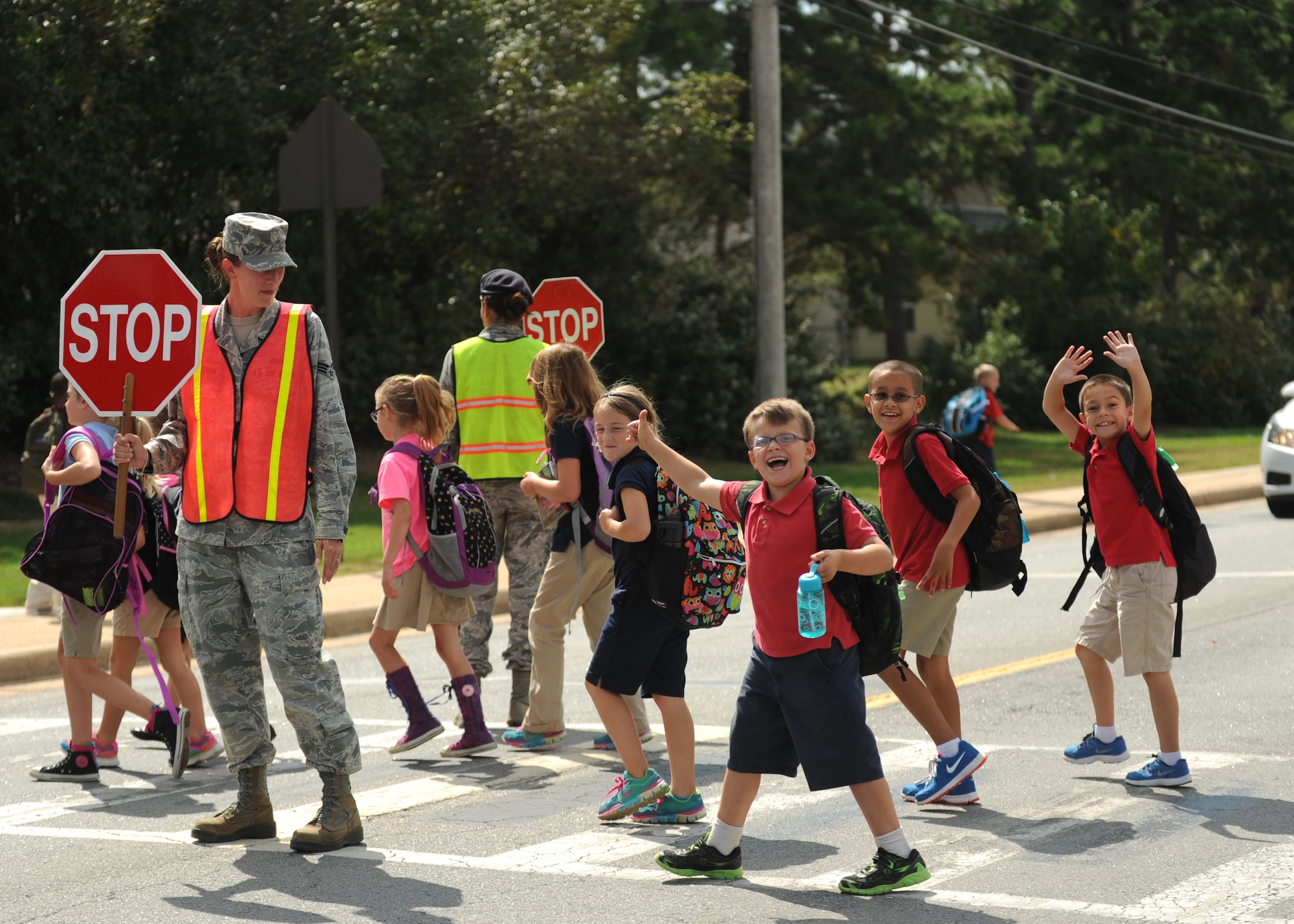Senior Airman Jill Anderson, a 314th Aircraft Maintenance Squadron training monitor, along with Airman 1st Class Jessica Sigler, a 19th Security Forces Squadron flight member, assists school children crossing the street after school Sept. 10, 2014, at Little Rock Air Force Base, Ark. There are multiple volunteer opportunities on and off base. To find out how you can help, call the Airmen and Family Readiness Center at (501) 987-2667. (U.S. Air Force photo by Airman 1st Class Scott Poe)