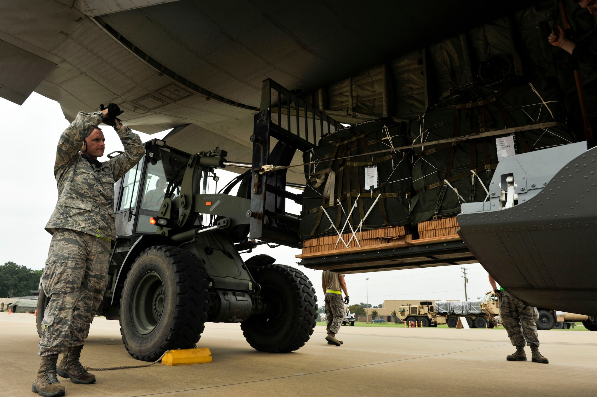 Senior Master Sgt. Ryan Holmes, the 819th Global Support Squadron Mission Support Flight superintendent from Joint Base McGuire-Dix-Lakehurst, N.J., directs aerial porters who are loading eight container delivery system bundles on a C-130 for an airdrop at the Alexandria International Airport Sept. 18, 2014. These pallets contained vital supplies for delivery to the Army field unit enabling their combat simulation to continue. (U.S. Air Force photos by Senior Airman Regina Agoha)    